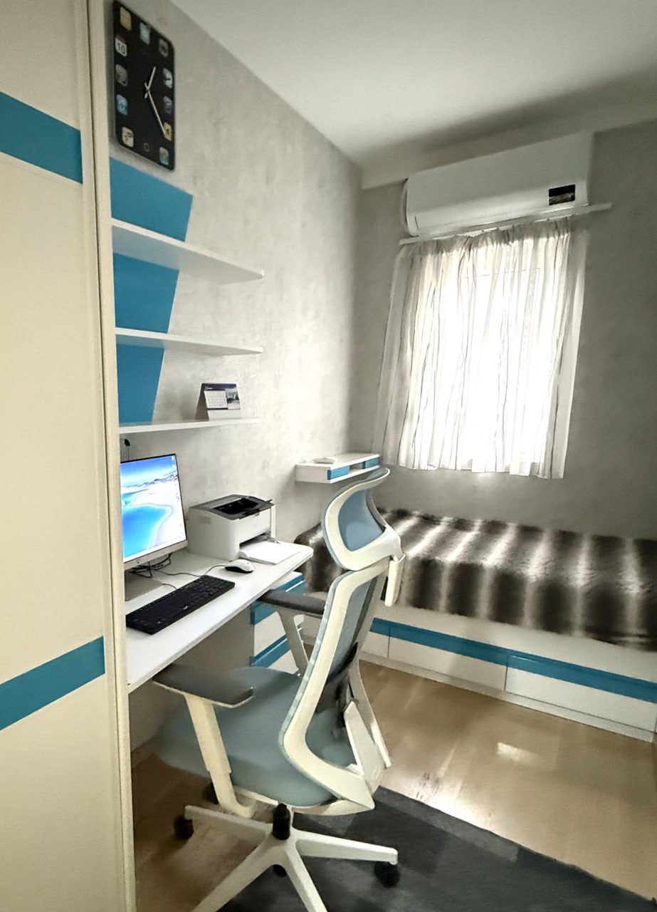 Cozy bedroom with a workspace in an apartment in Podgorica, Montenegro: bed, computer desk, and air conditioner.