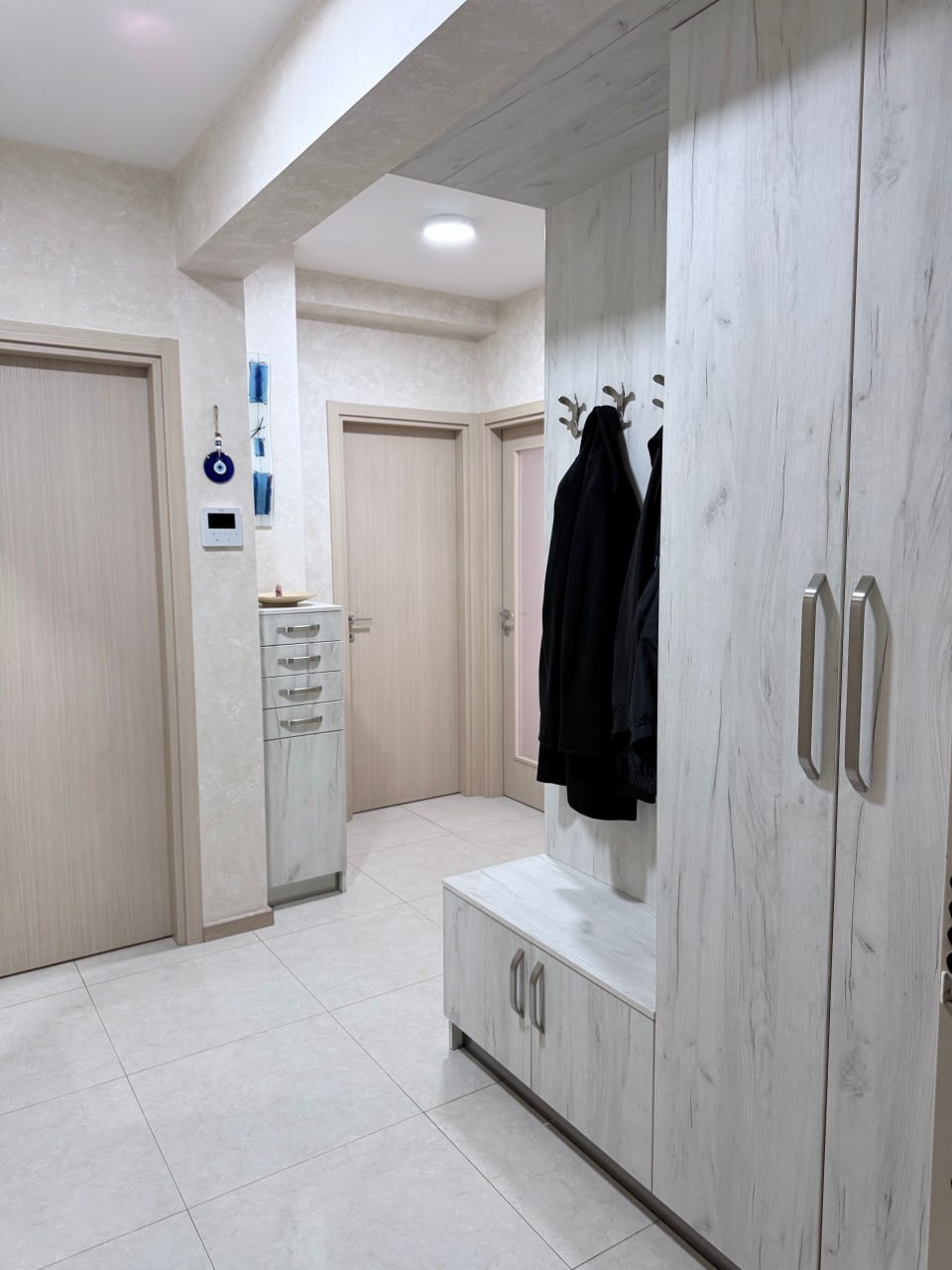 Bright hallway with a built-in wardrobe and wood-style furniture in an apartment in Podgorica, Montenegro.