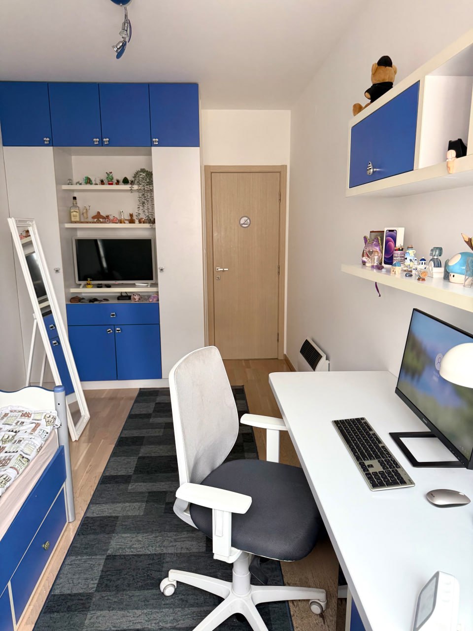 Children's bedroom with a workspace and blue furniture in an apartment in Podgorica, Montenegro. Modern interior with a PC.