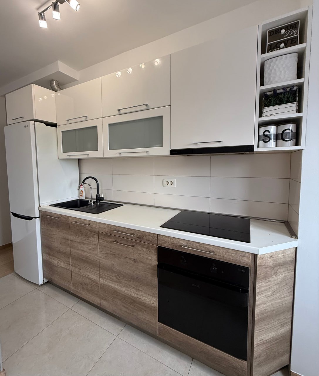 Modern kitchen in an apartment in Podgorica, Montenegro: white kitchen set, wooden facades, built-in appliances, and tiling.