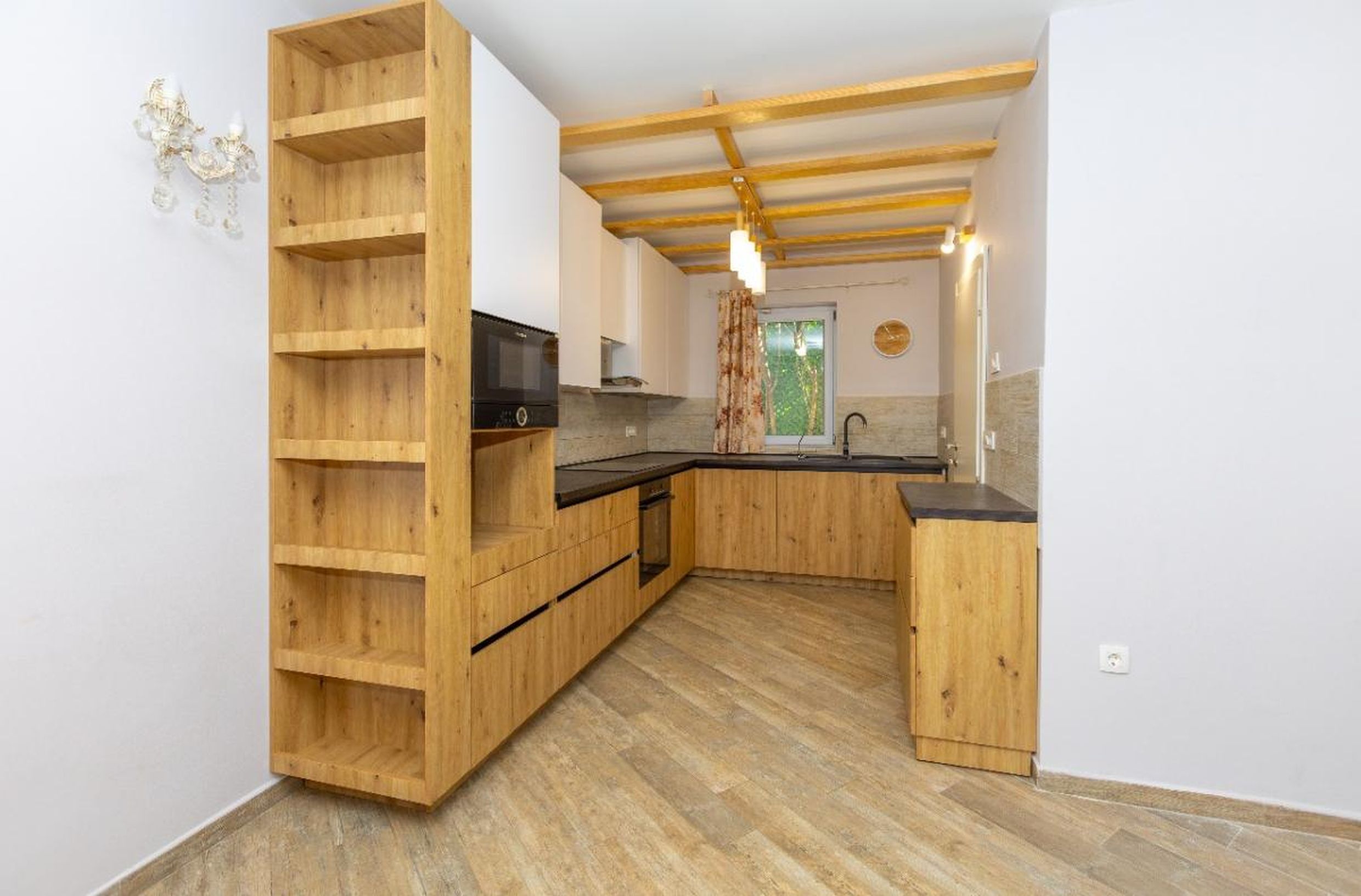 Modern kitchen with wooden fronts and ceiling beams in a house for sale, Tivat, Montenegro.