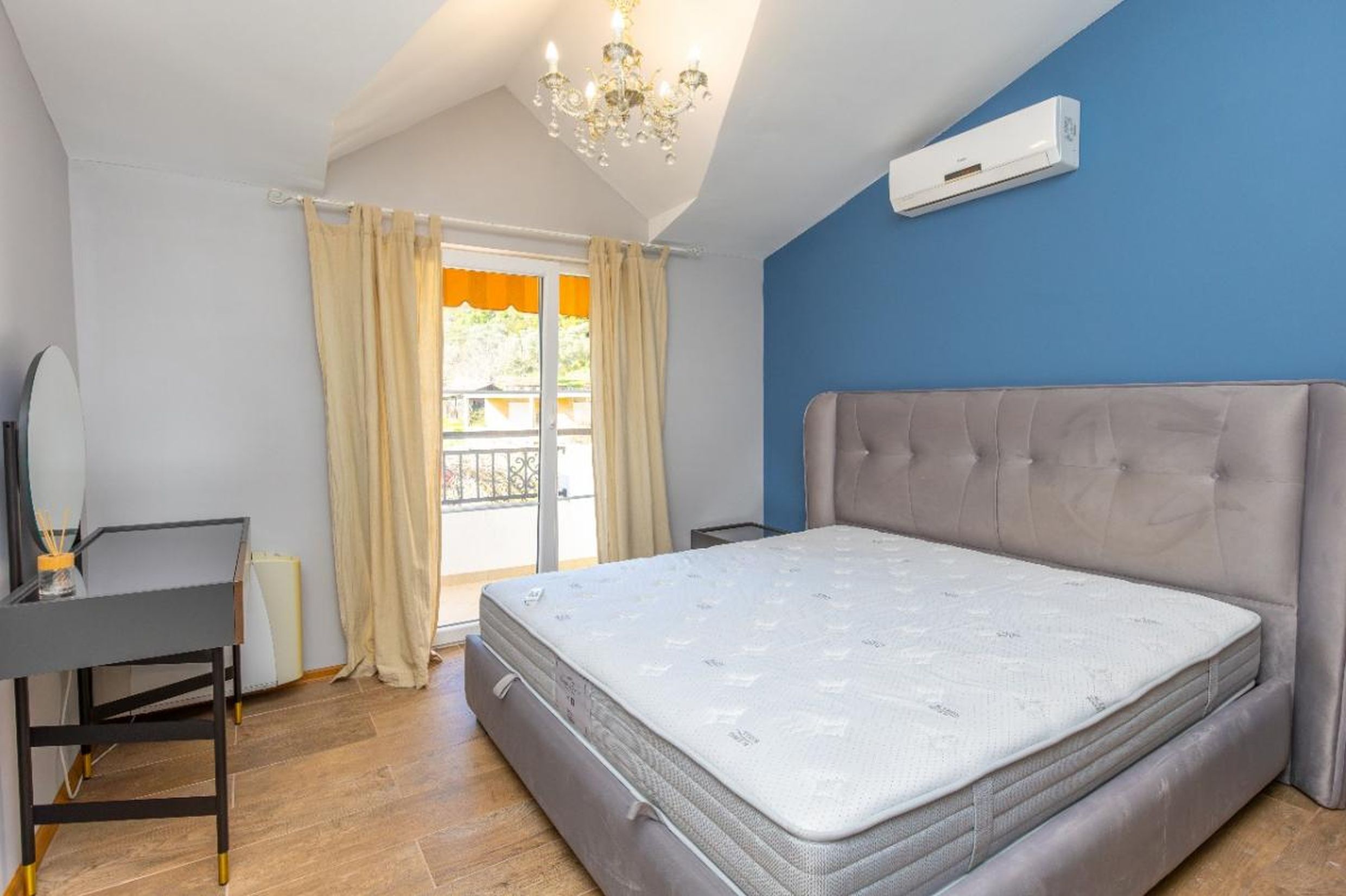 Bedroom in a house in Tivat, Montenegro: double bed, vanity table, balcony access, and high ceilings.