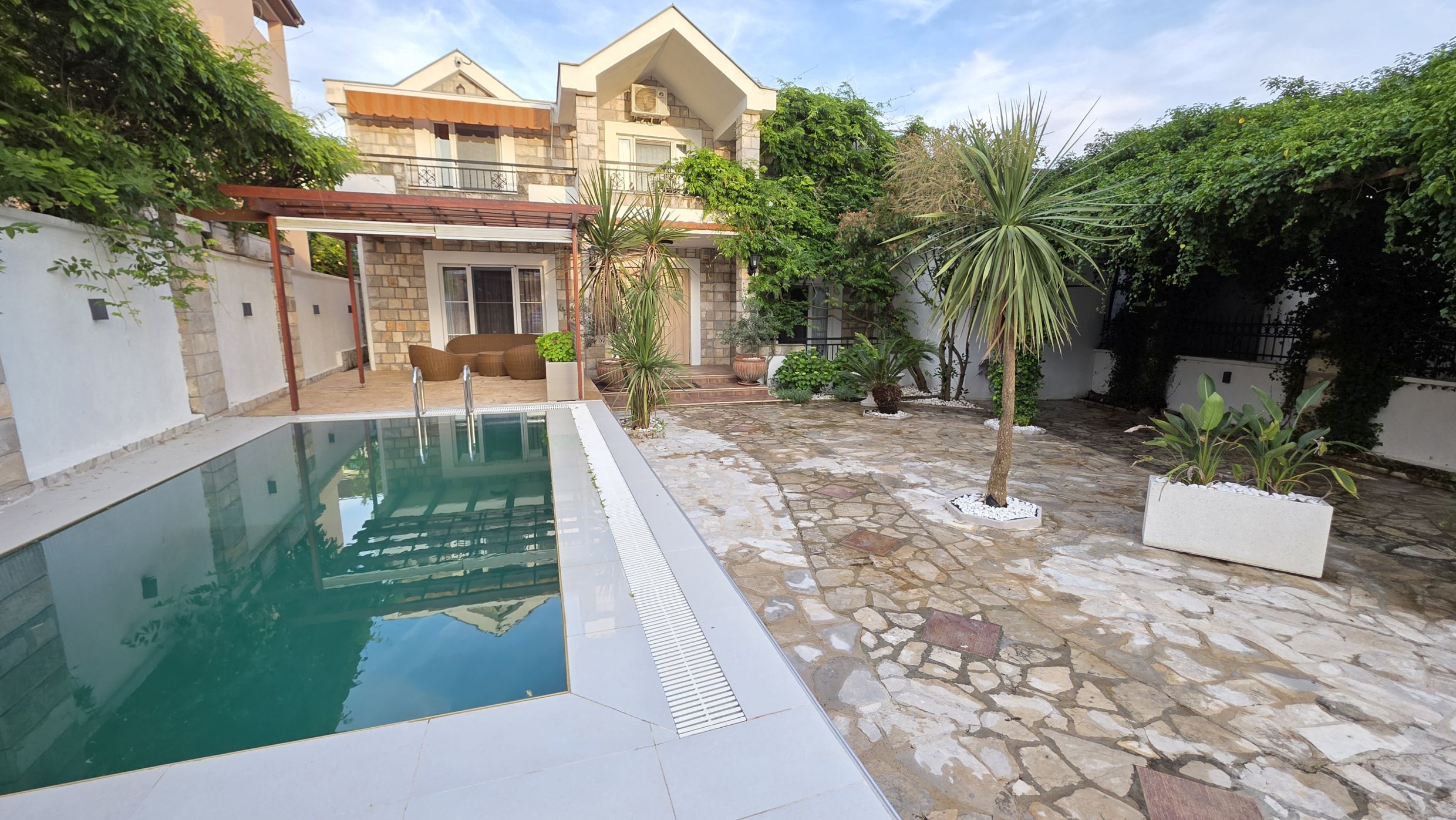 Two-story villa in Tivat, Montenegro: stone facade, private pool, furnished terrace, and a well-kept garden.