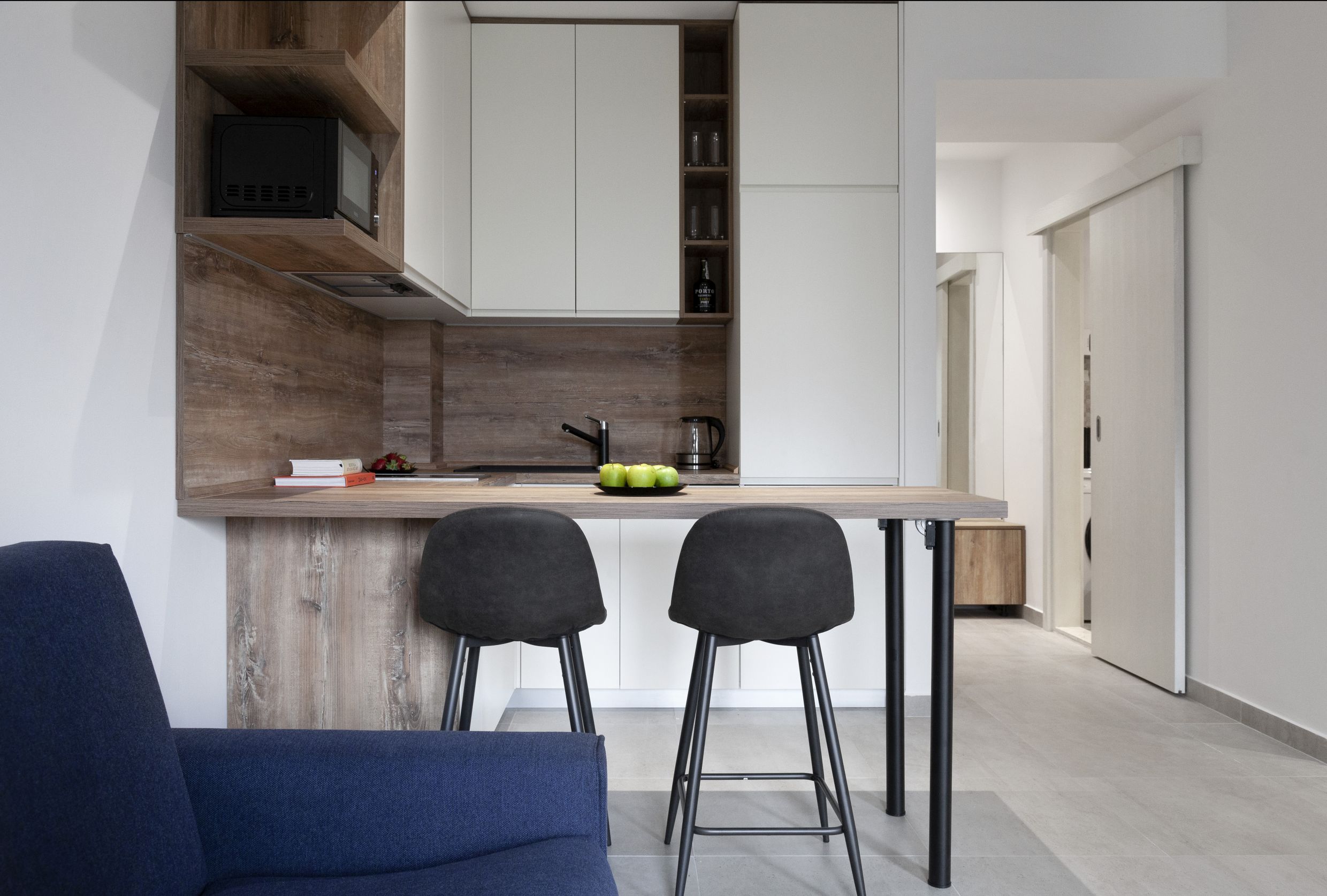 Modern studio kitchen with a bar counter in an apartment for sale in Kotor, Montenegro: stylish interior and furniture.