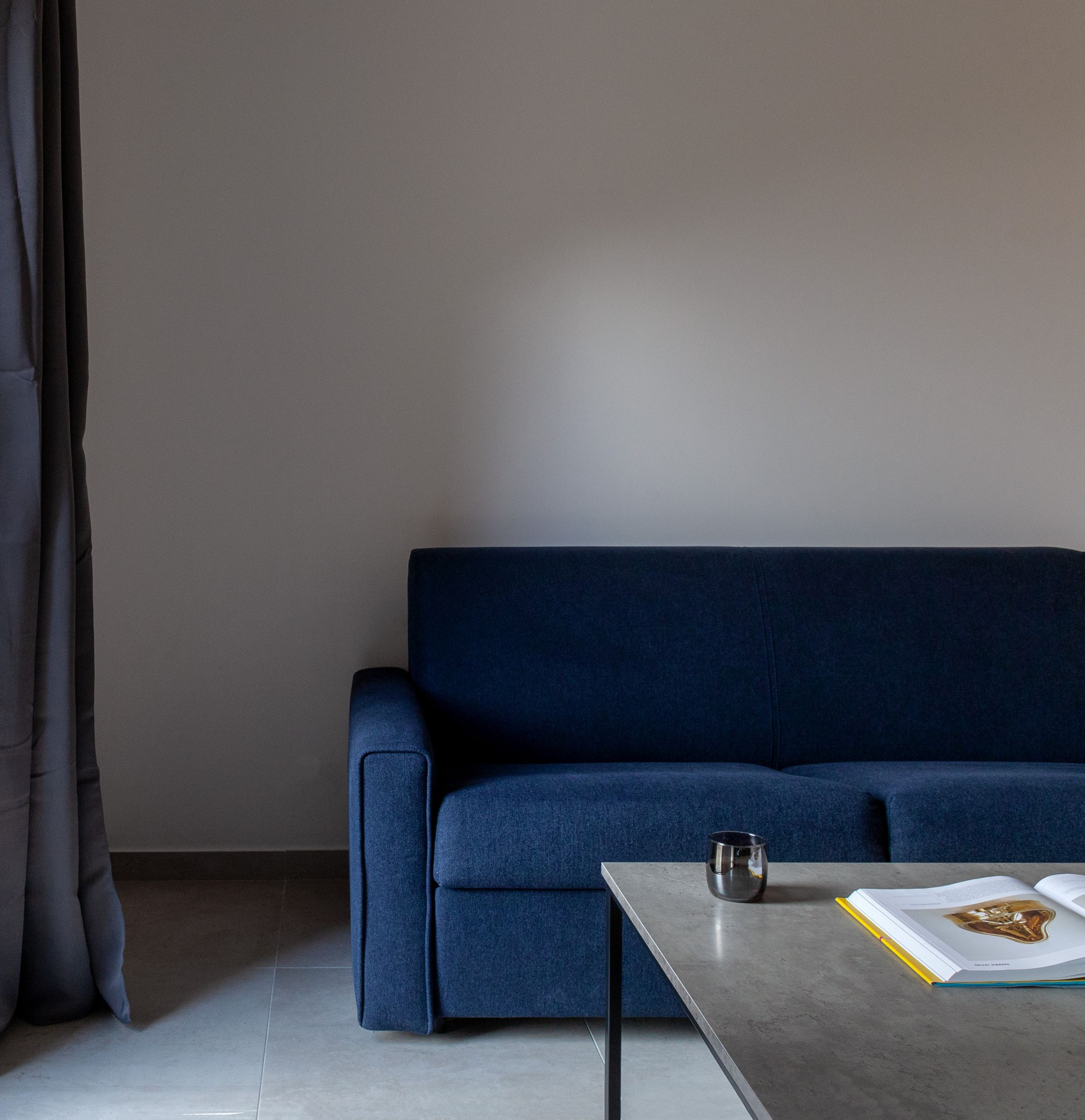 Modern living room with a blue sofa and coffee table in an apartment in Kotor, Montenegro.