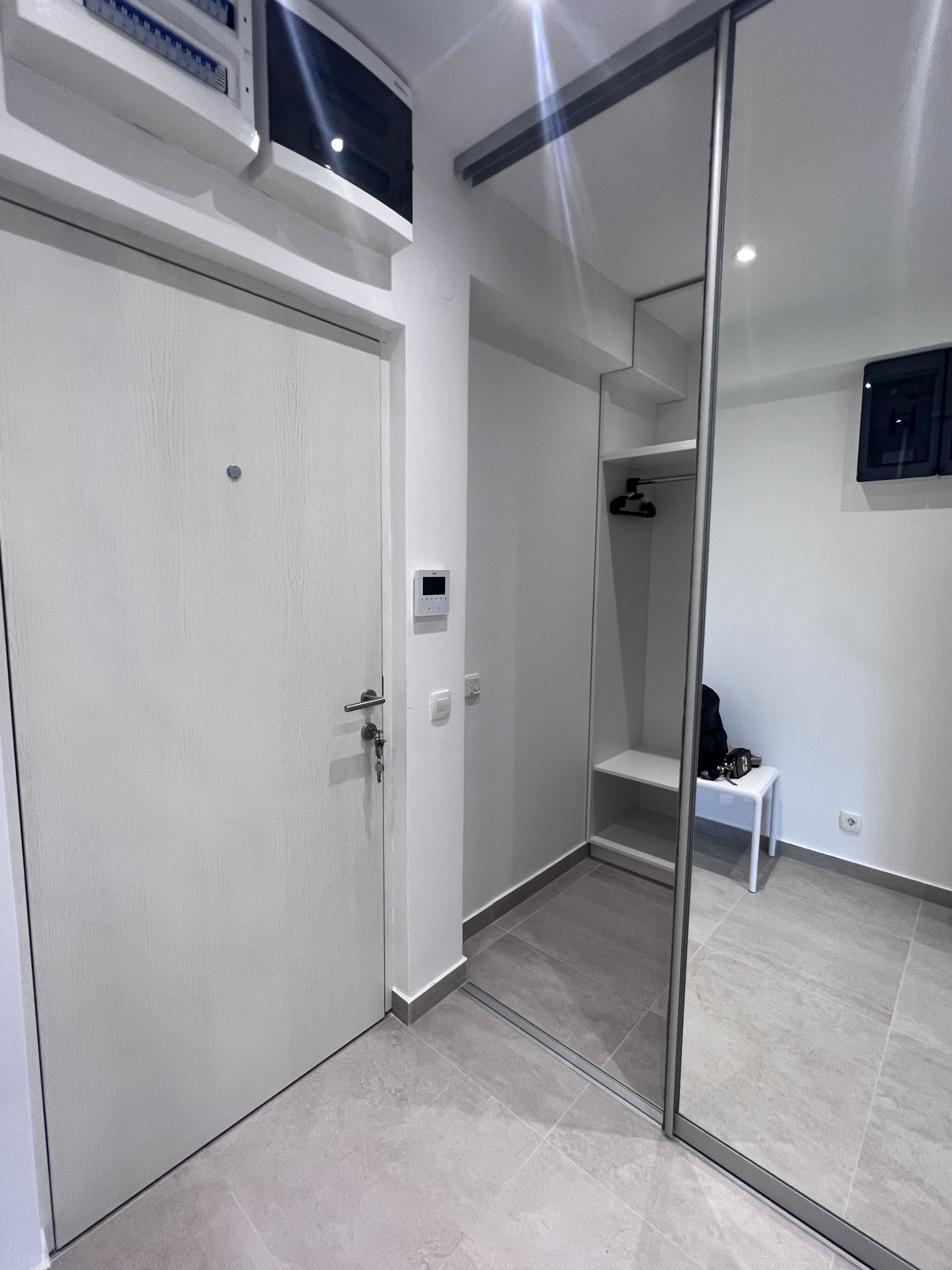Bright hallway with a mirrored sliding wardrobe in a modern apartment in Kotor, Montenegro.