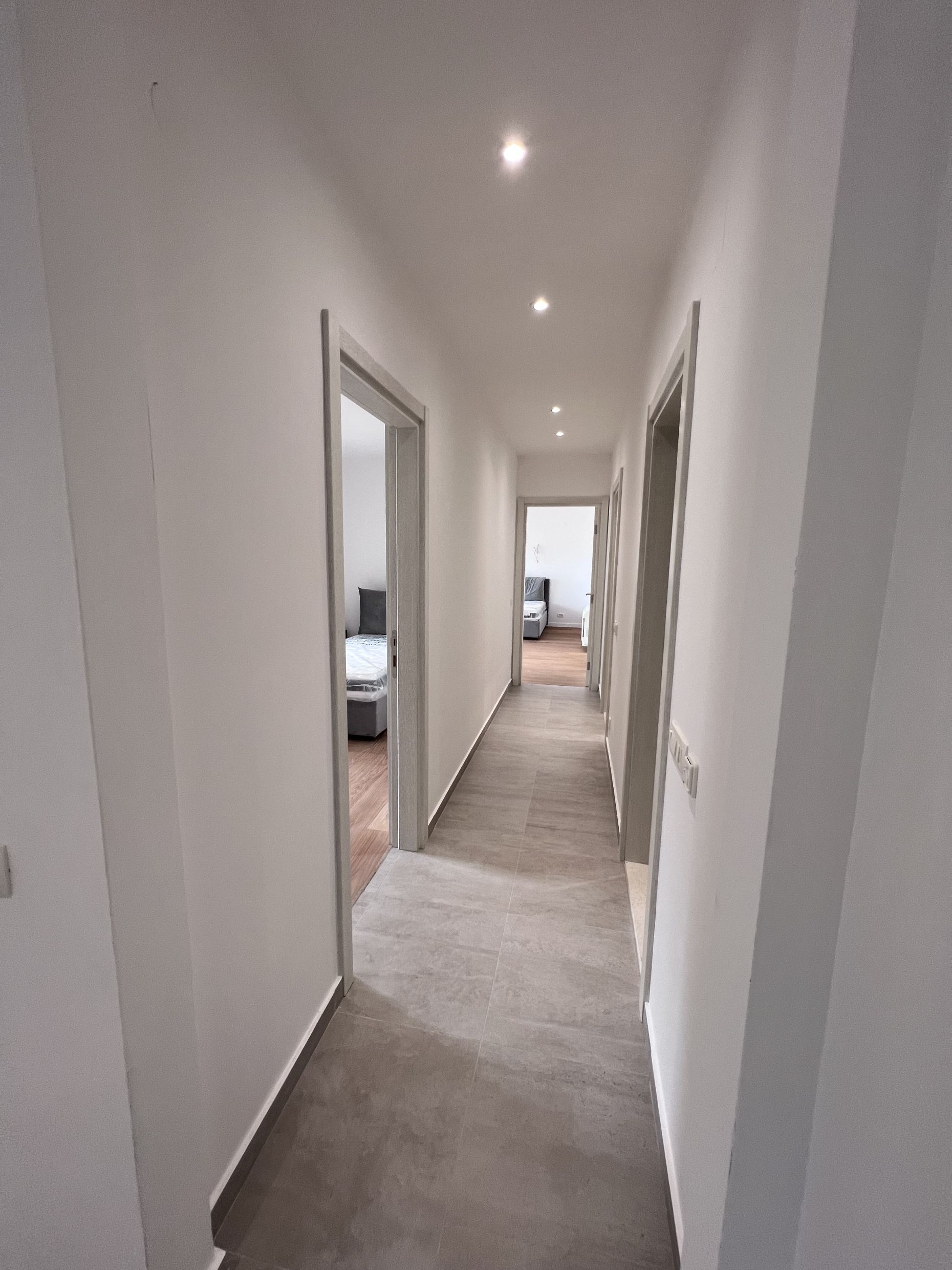 Bright hallway with modern finishes and recessed lighting in an apartment in Kotor, Montenegro.