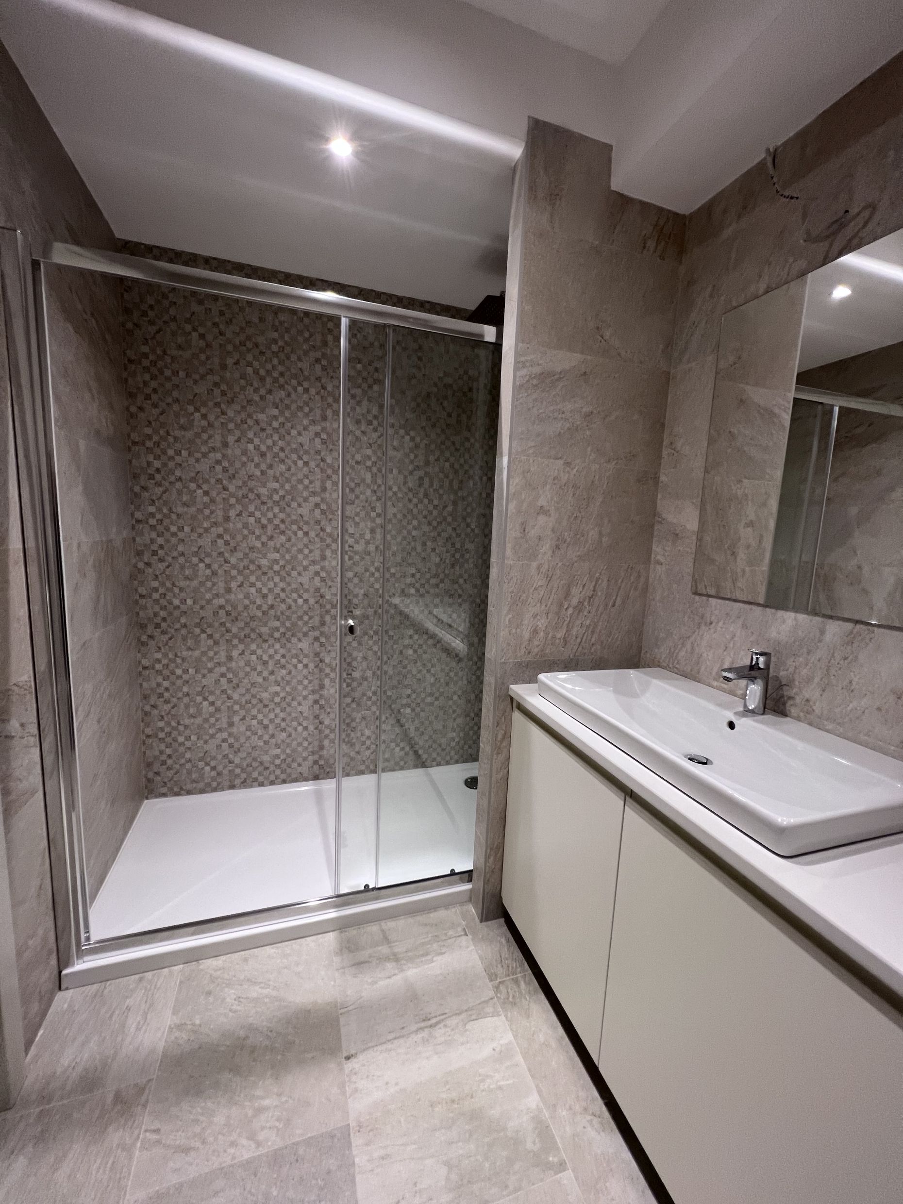 Modern bathroom with a shower cabin and vanity unit in an apartment, Kotor, Montenegro.