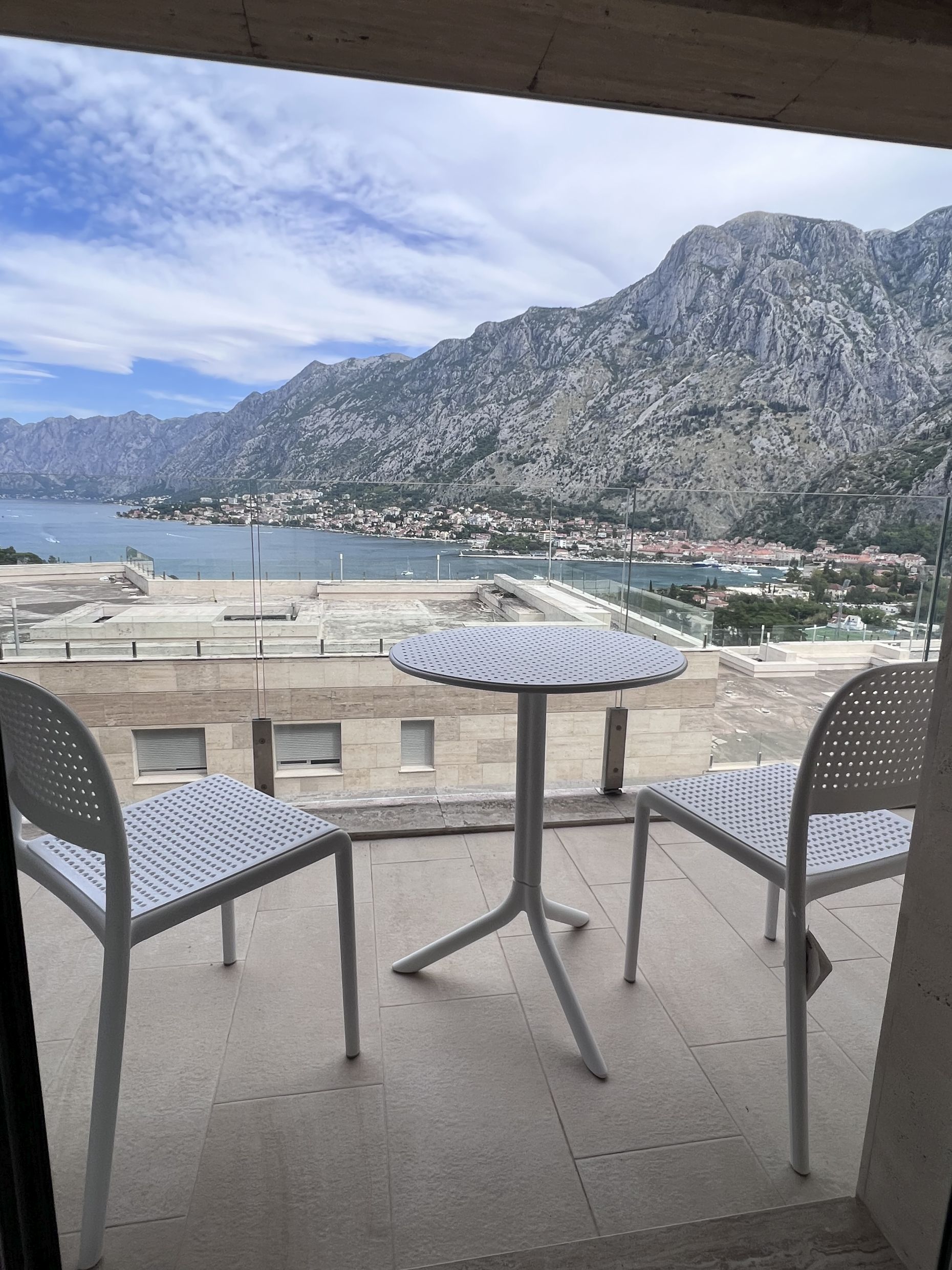 Balcony with furniture and panoramic views of Kotor Bay and the mountains, apartment in Kotor, Montenegro.