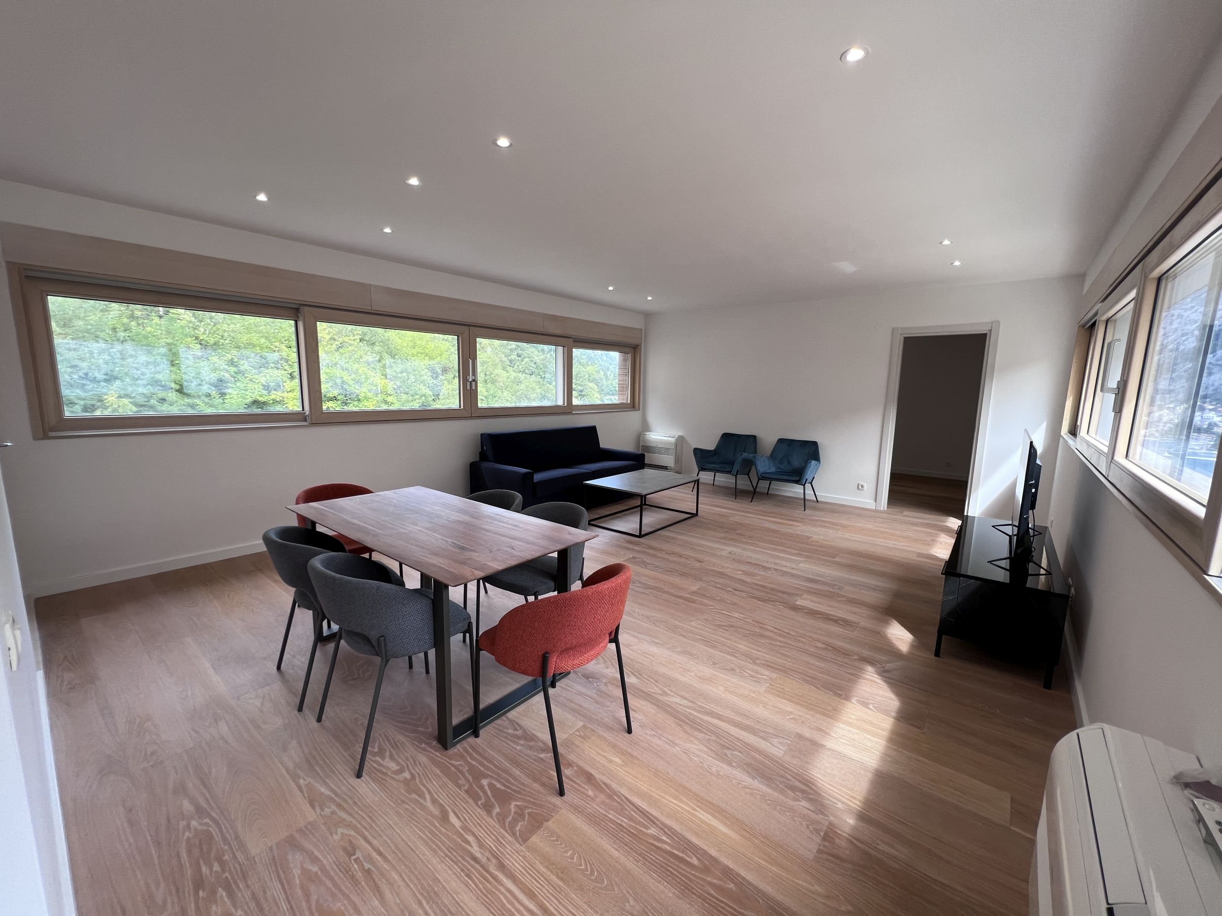 Spacious living room with dining area and panoramic windows in a modern apartment, Kotor, Montenegro.