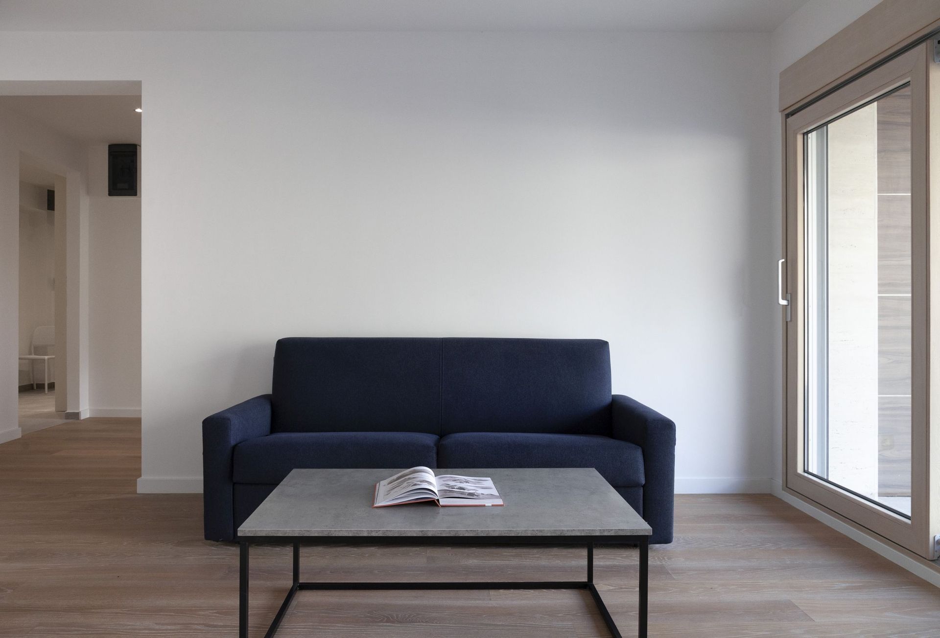 Modern living room with a dark blue sofa and coffee table in an apartment in Kotor, Montenegro.