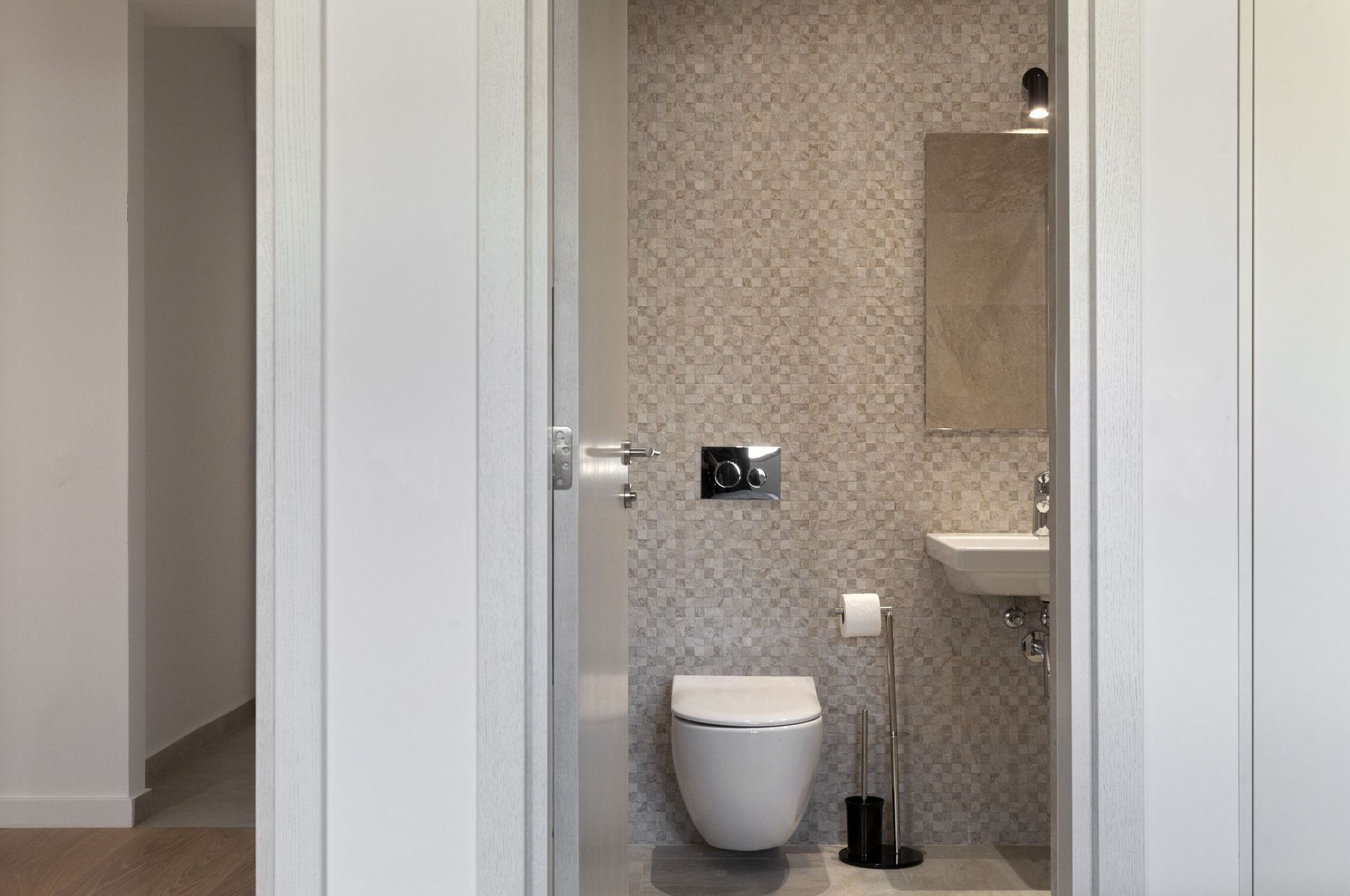 Modern bathroom with a wall-mounted toilet and mosaic tile in an apartment, Kotor, Montenegro.