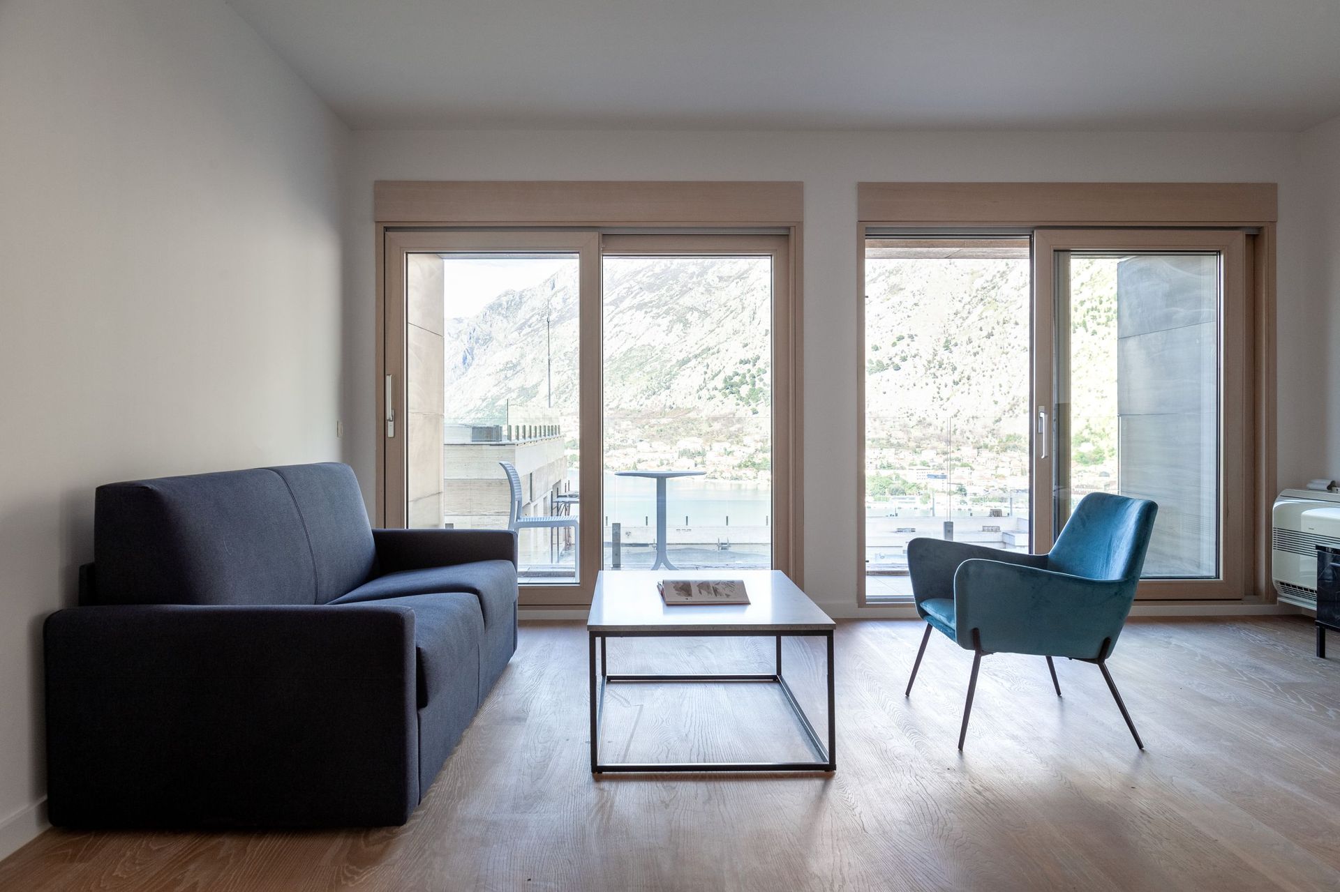 Living room with panoramic views of the mountains and bay in an apartment in Kotor, Montenegro: modern furniture and a bright interior.