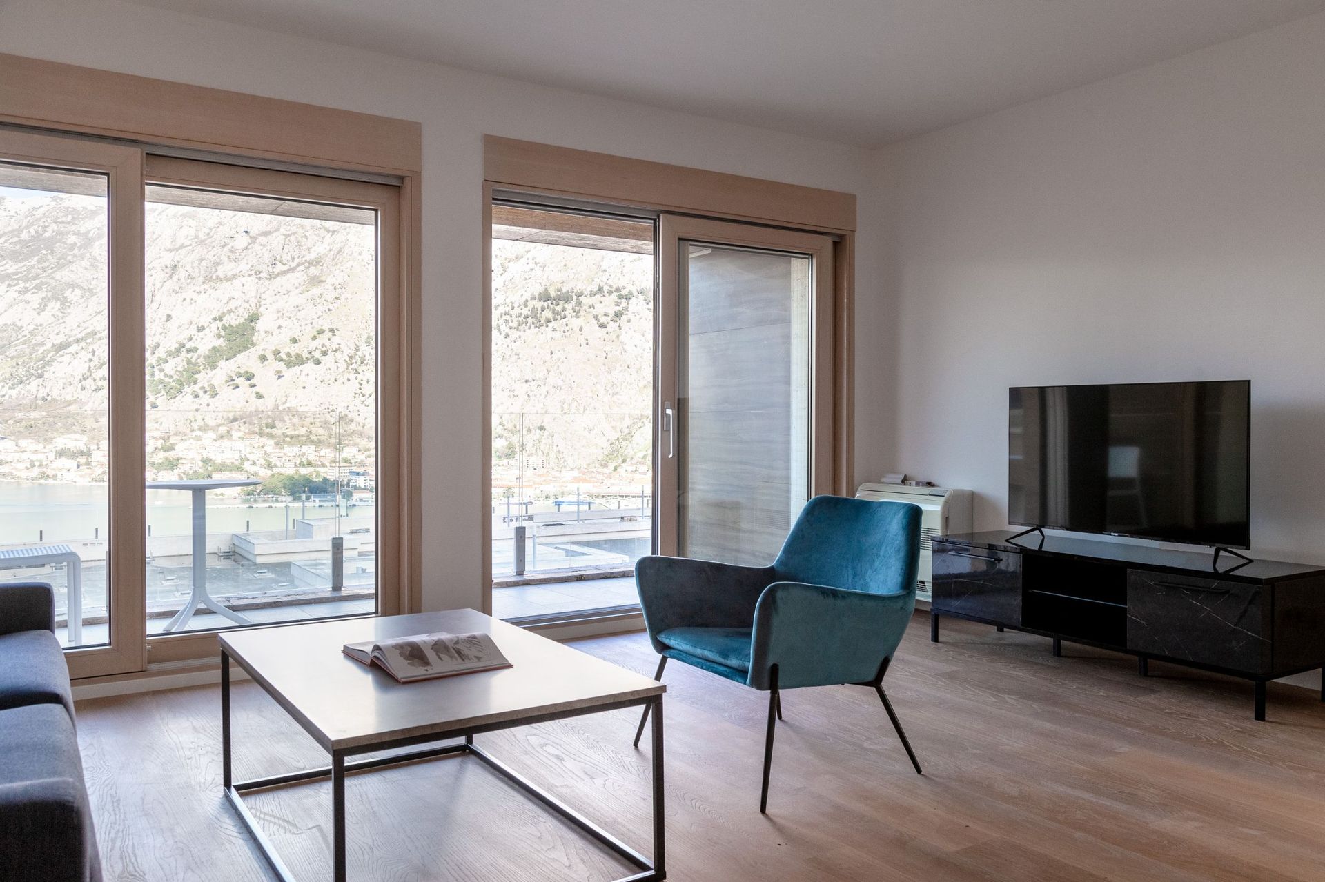 Living room with panoramic views of Kotor Bay, modern furniture, and a terrace in the apartment, Kotor, Montenegro.