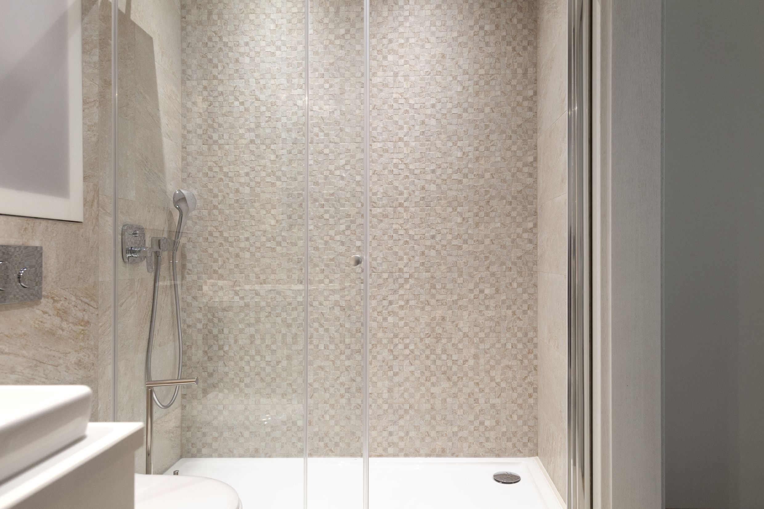 Modern shower cabin with mosaic tile in the bathroom of an apartment in Kotor, Montenegro.