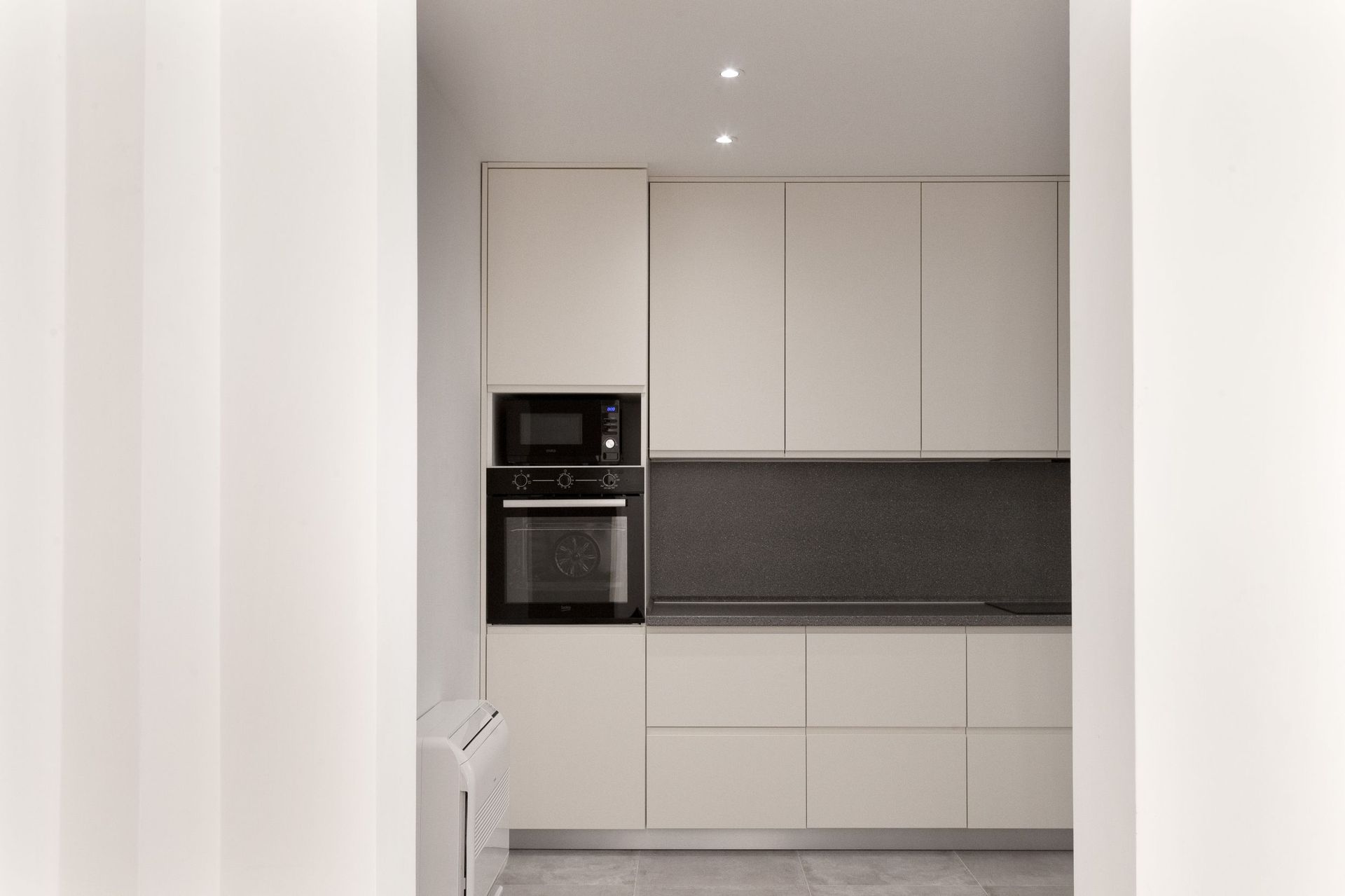 Modern bright kitchen with built-in appliances in an apartment in Kotor, Montenegro. Minimalist interior design.