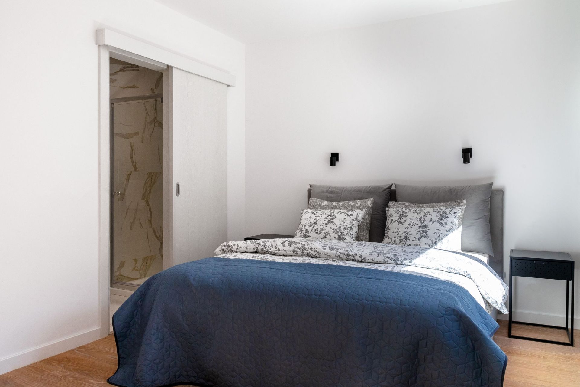 Modern bedroom with a double bed and bathroom in an apartment in Kotor, Montenegro.