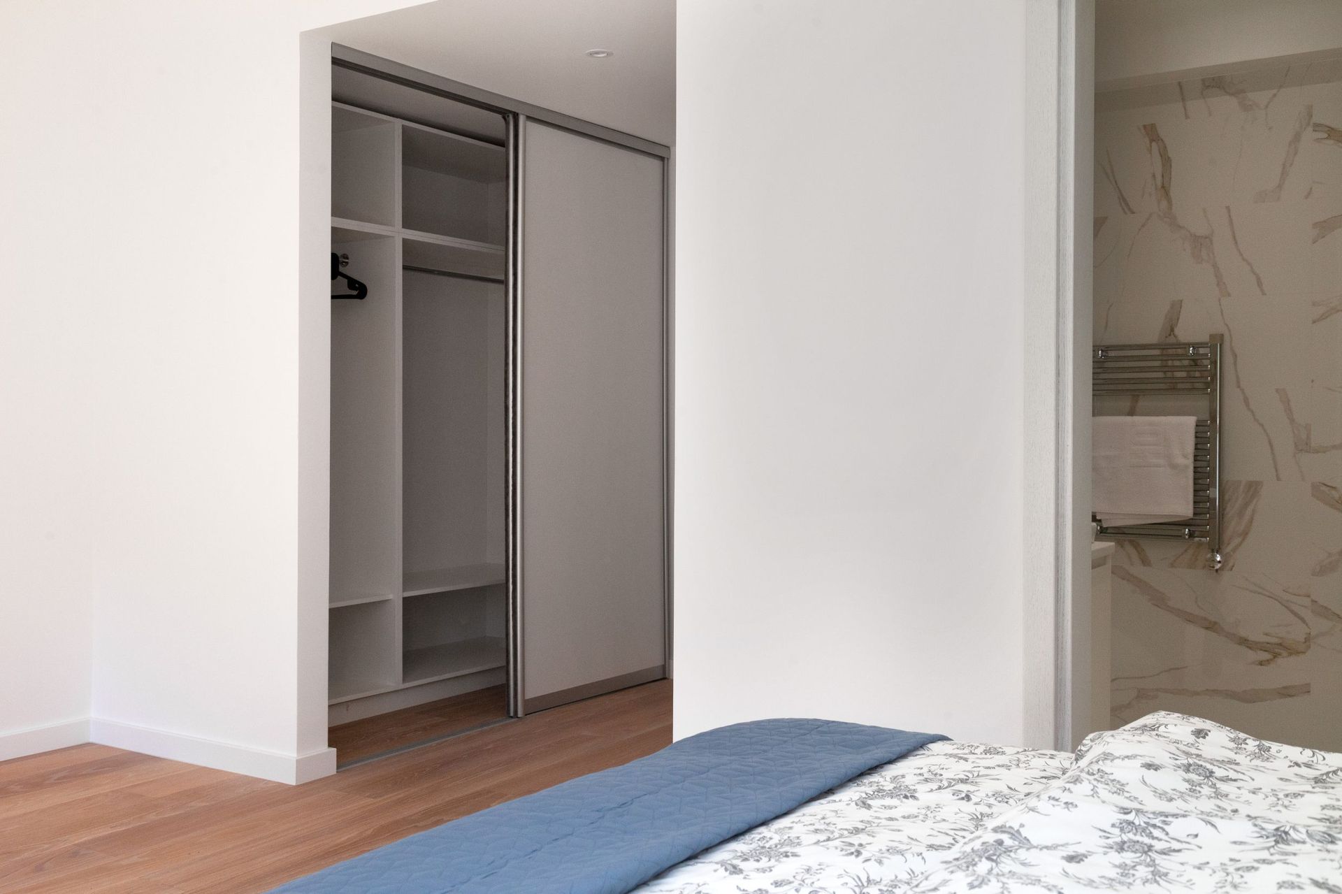 Bedroom with a walk-in closet and en-suite bathroom in a modern apartment in Kotor, Montenegro: bright interior and finishes.