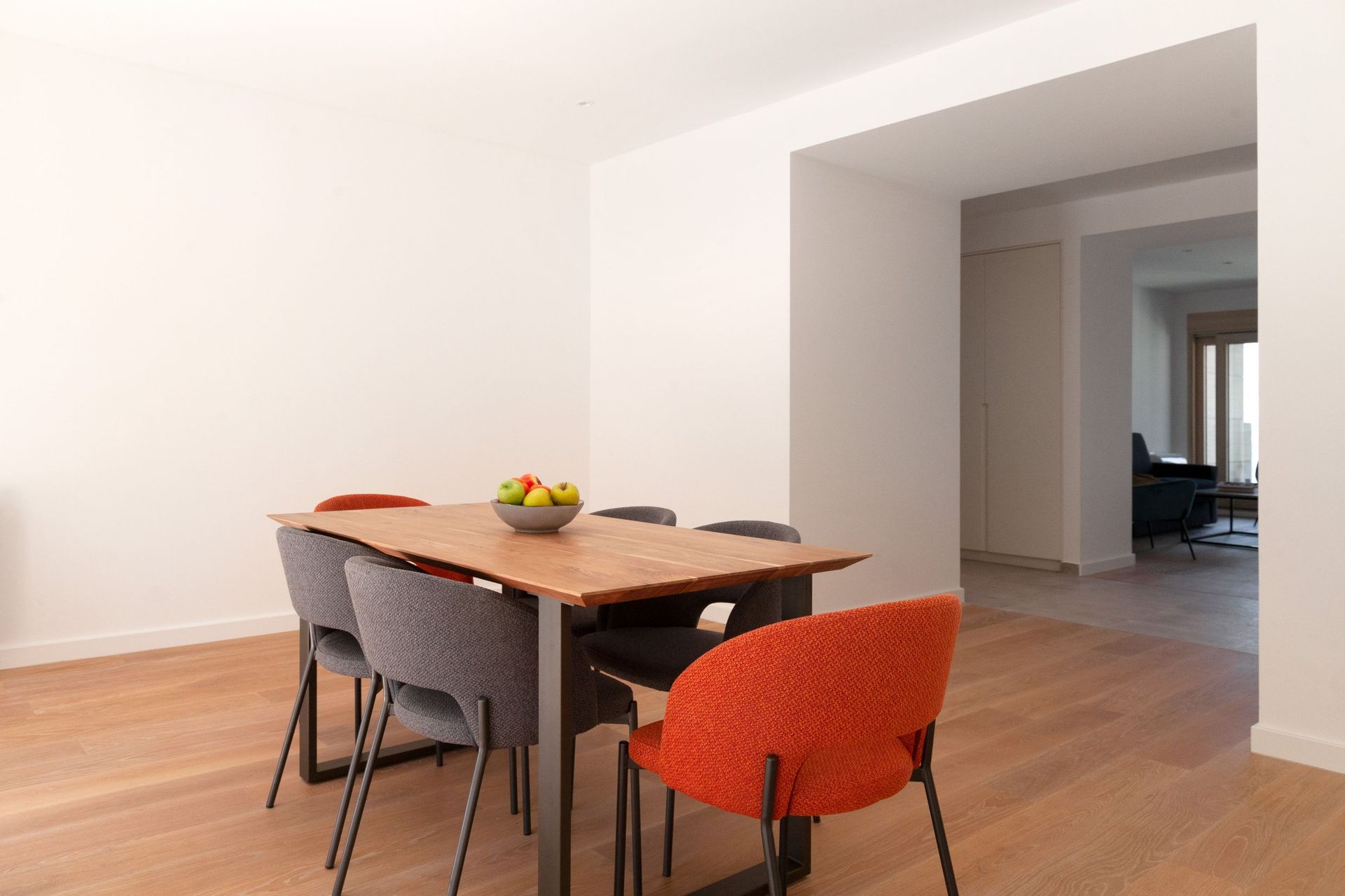 Modern dining area with a wooden table and bright chairs in an apartment, Kotor, Montenegro.