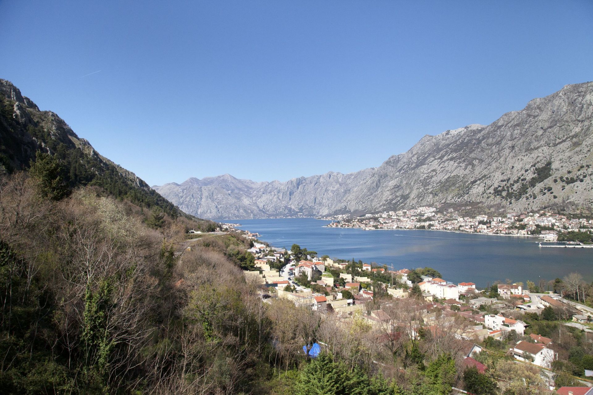 Panoramic view of the Bay of Kotor and mountains from an apartment in Kotor, Montenegro: coastal town and seascape.