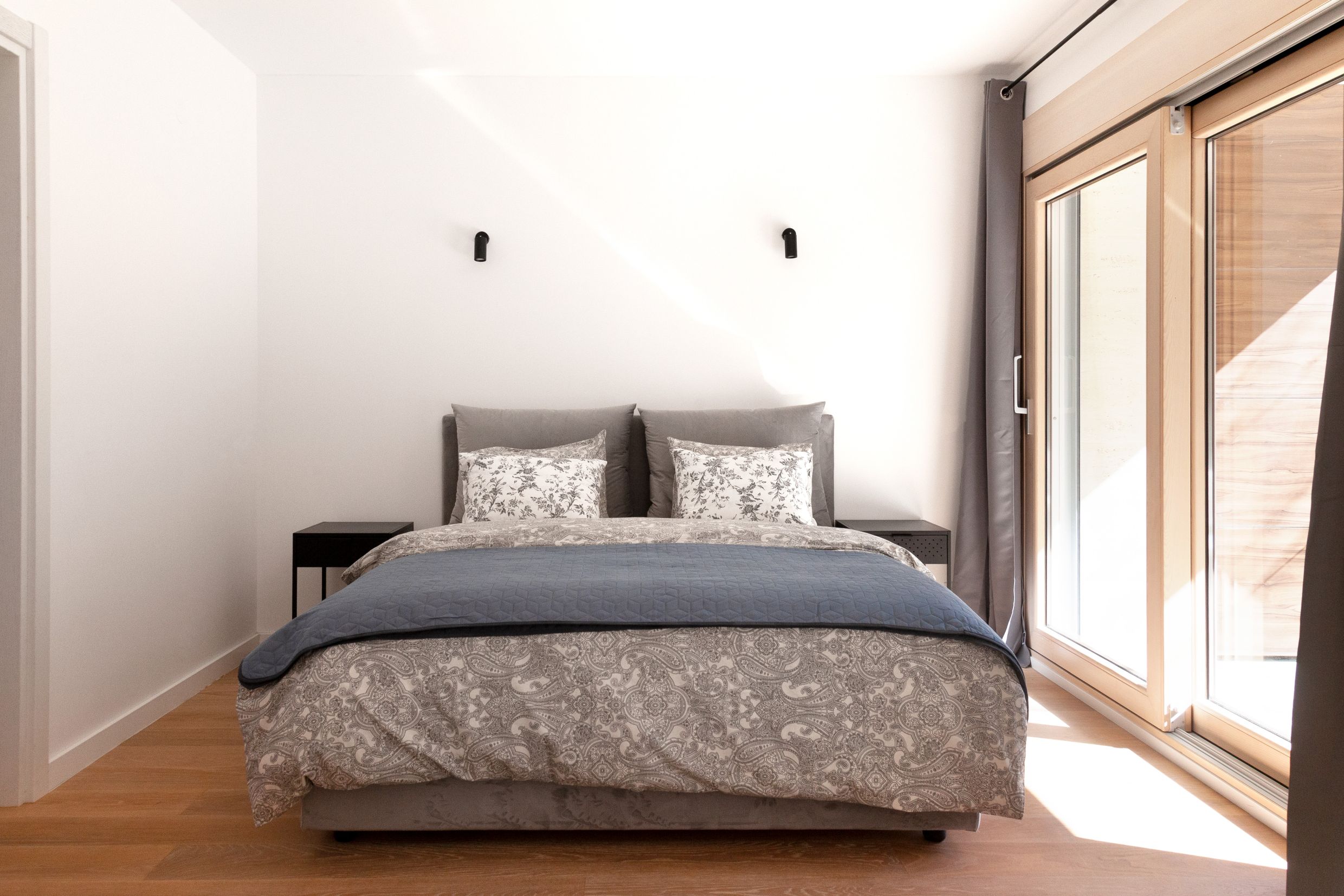 Modern bedroom with a double bed and a panoramic window in an apartment in Kotor, Montenegro.