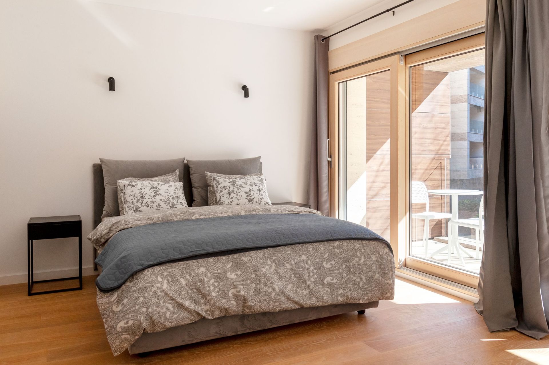 Modern bedroom in an apartment in Kotor, Montenegro: double bed, panoramic window, and access to the terrace.