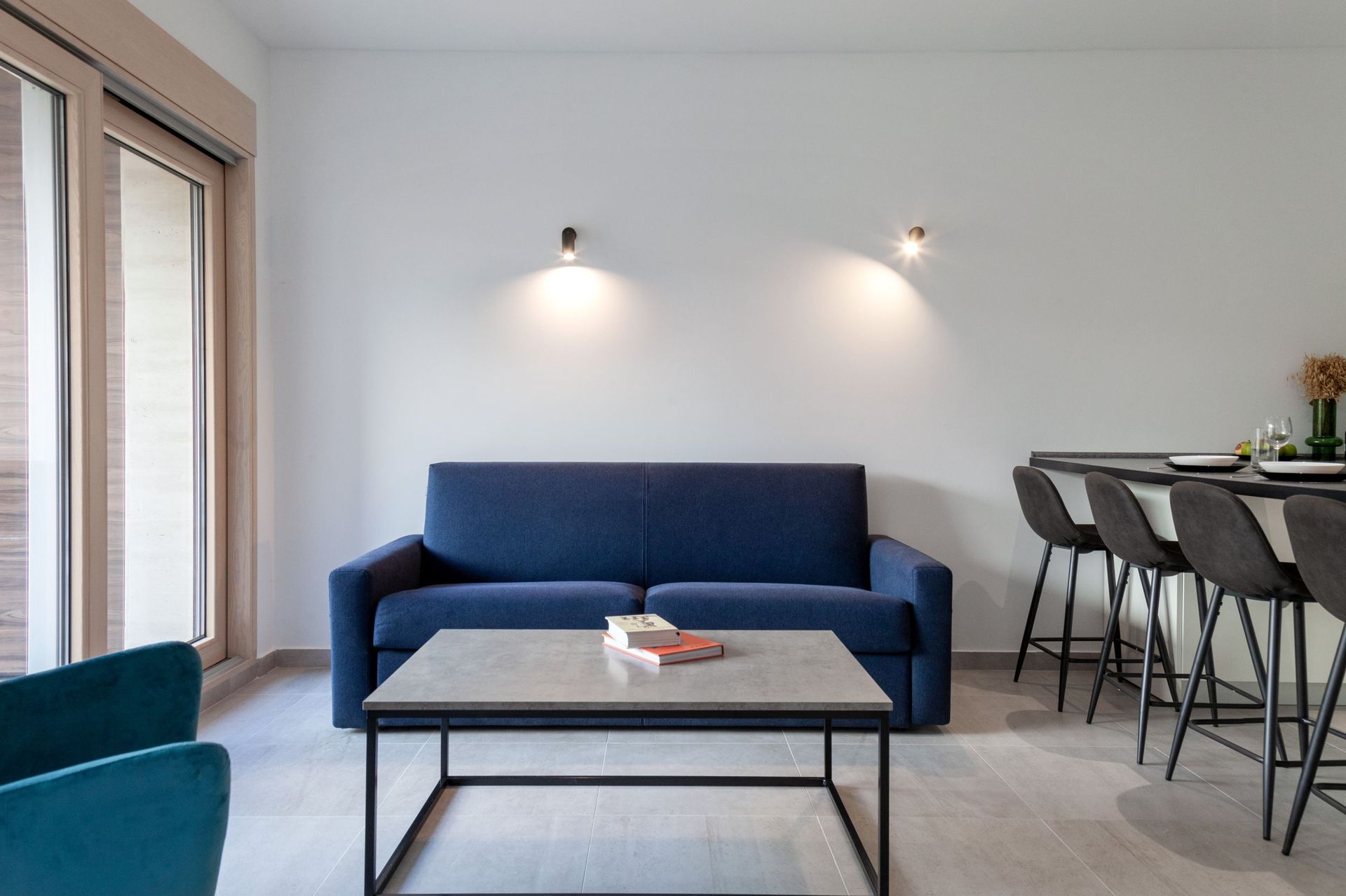 Modern living room with a blue sofa and a bar counter in an apartment in Kotor, Montenegro: stylish interior and decor.