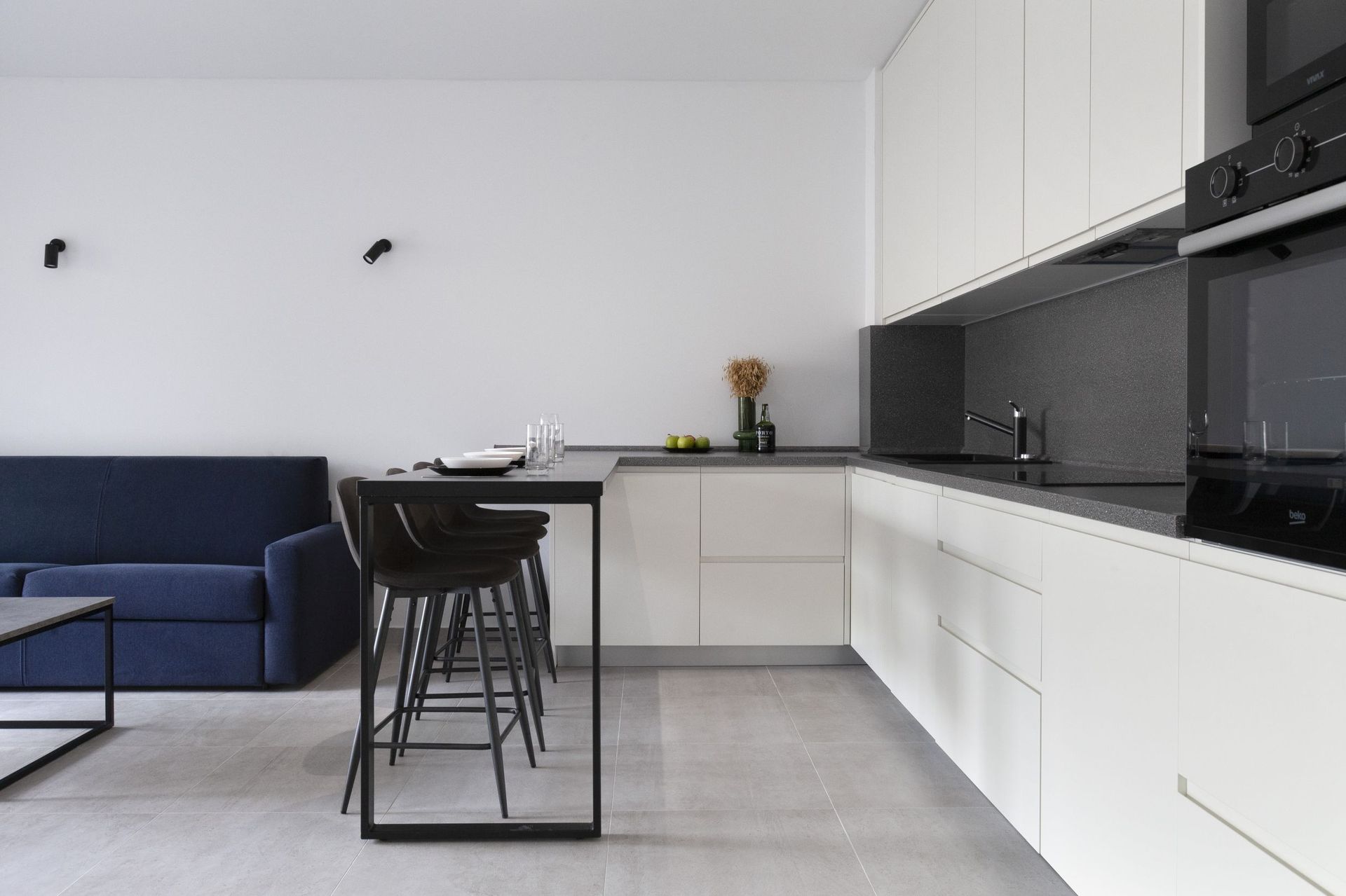 Modern kitchen-living room with white cabinetry and a breakfast bar in an apartment in Kotor, Montenegro.