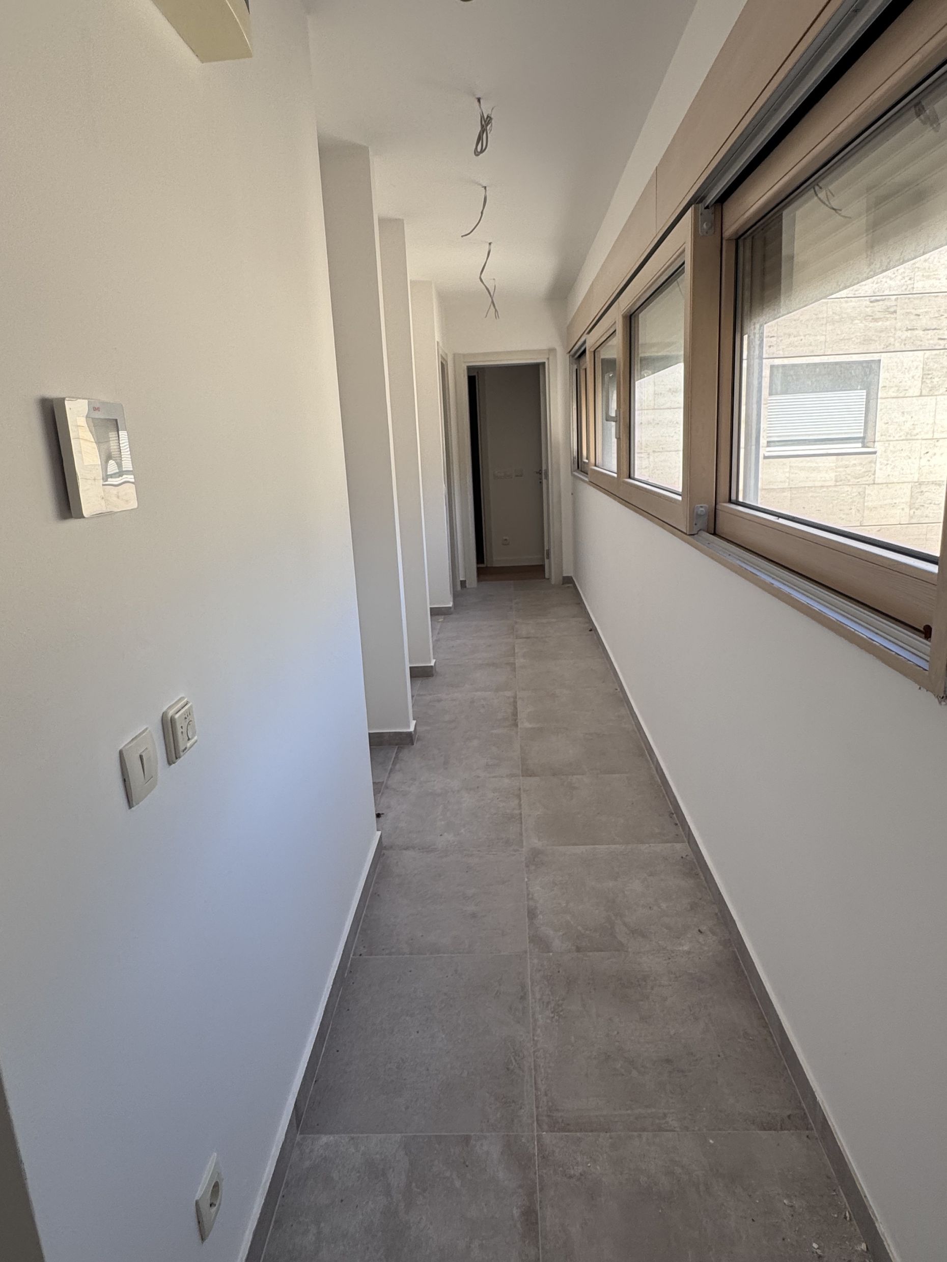 Bright hallway in an apartment in Kotor, Montenegro: panoramic windows, tiled floor, and modern wall finishes.