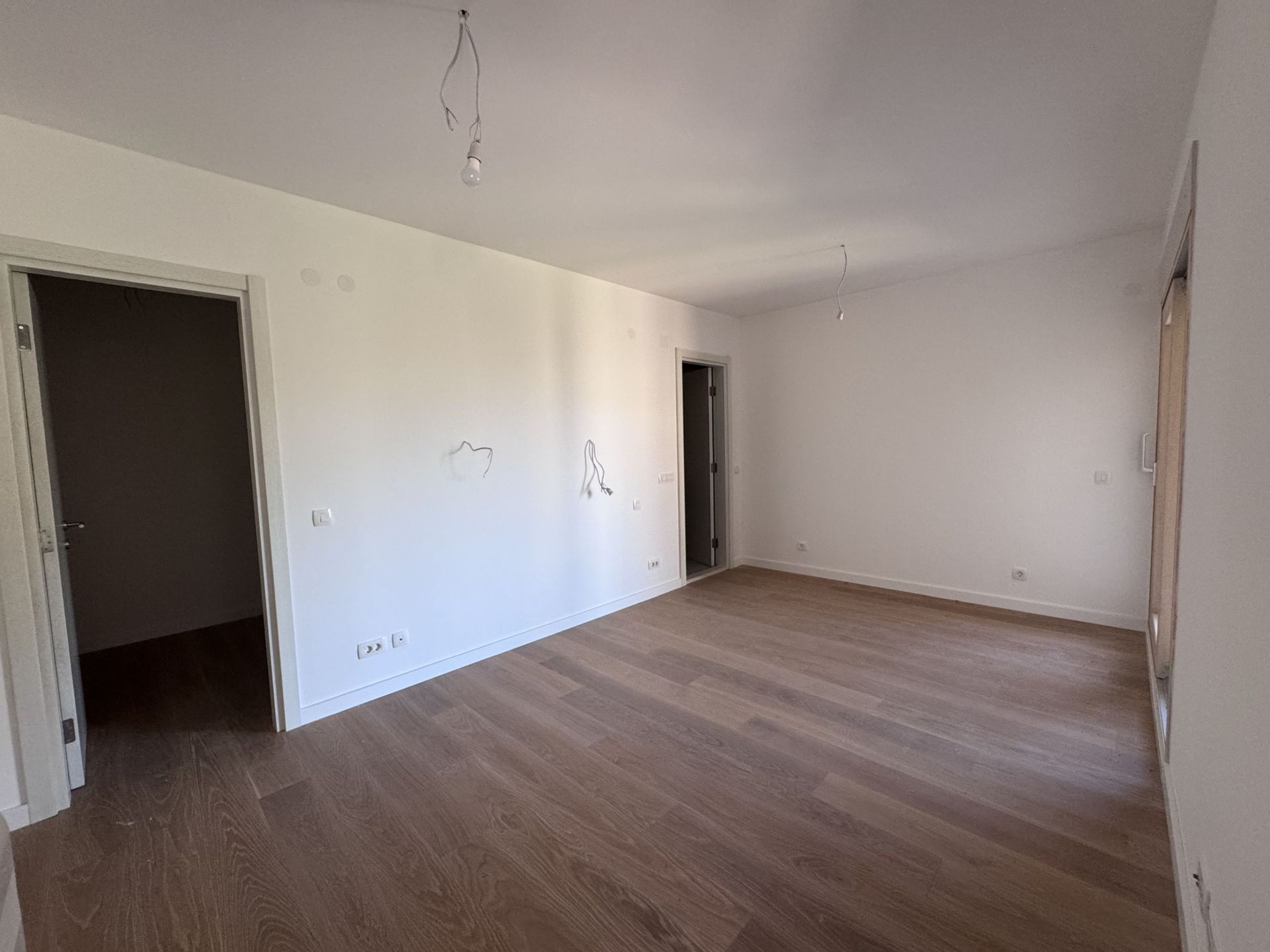Bright living room with parquet in a new apartment in Kotor, Montenegro: finished interior, interior doors, and light fixtures pre-installed