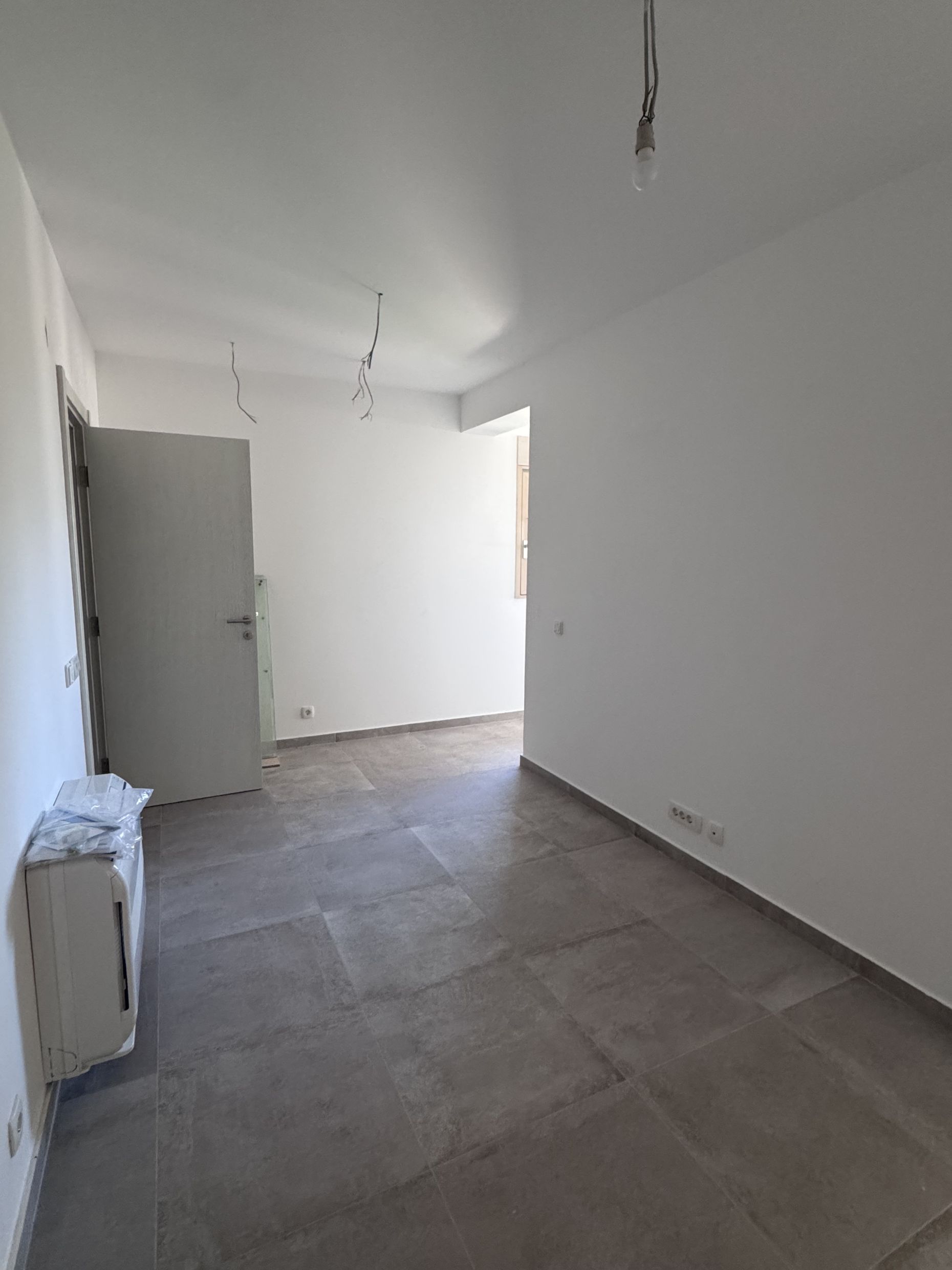 Bright living room with finished interior and floor tiles in a new apartment, Kotor, Montenegro.