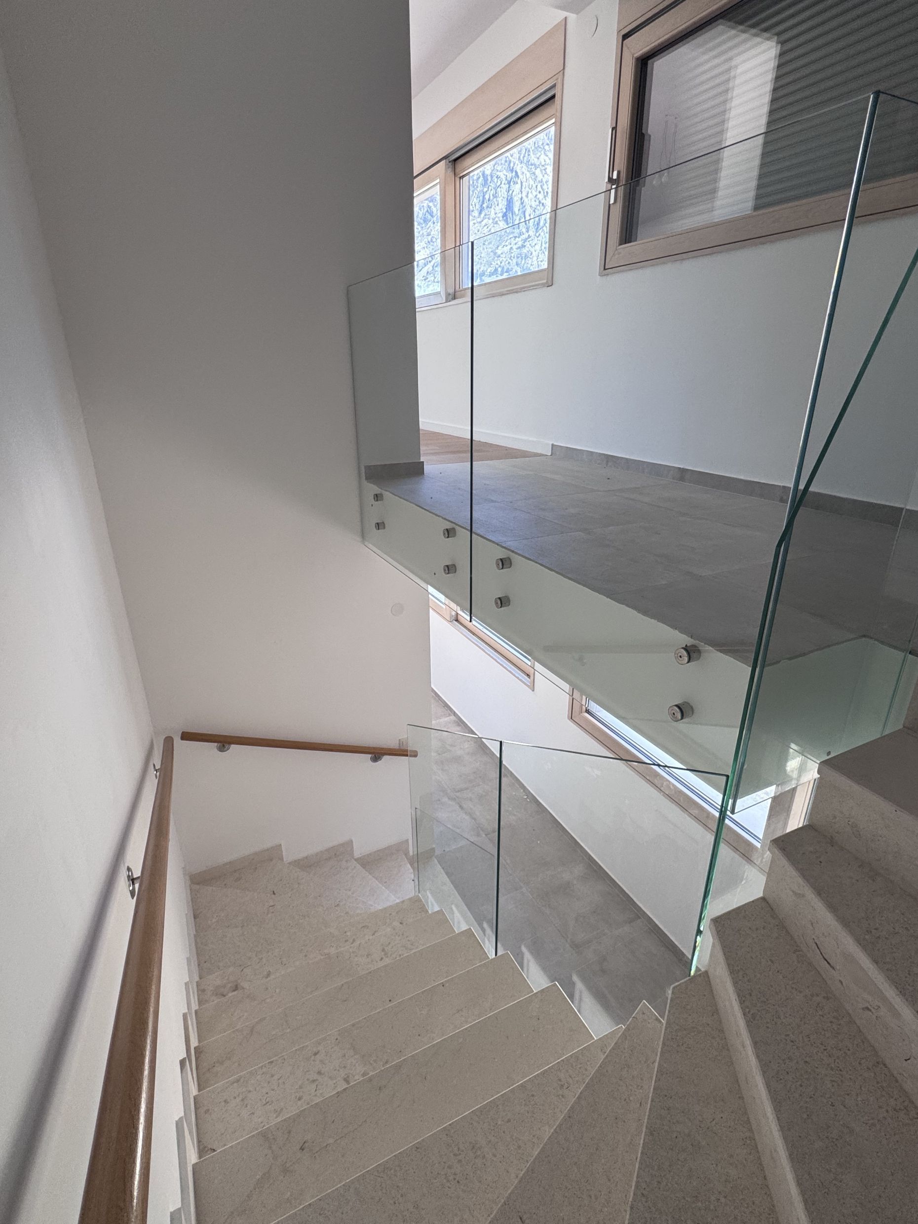 Modern staircase with stone steps and glass railing in a duplex, Kotor, Montenegro.