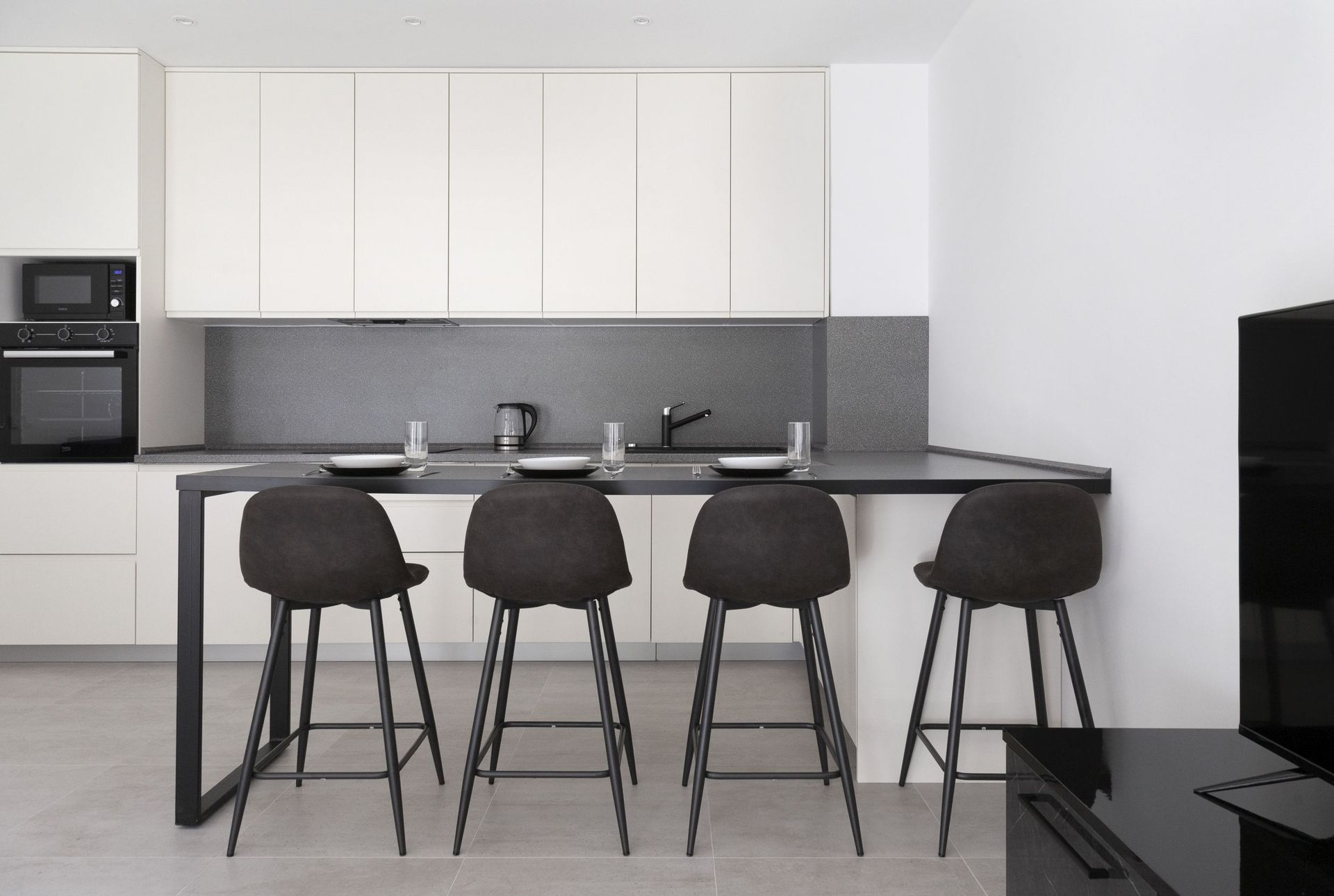 Modern kitchen with a breakfast bar and built-in appliances in an apartment, Kotor, Montenegro. Minimalist interior.
