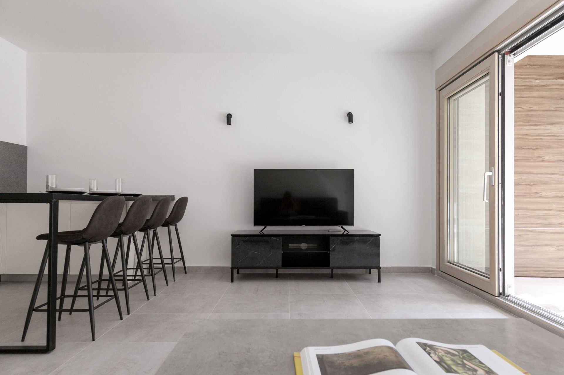 Modern living room with a bar counter and TV area in an apartment in Kotor, Montenegro: minimalist interior.