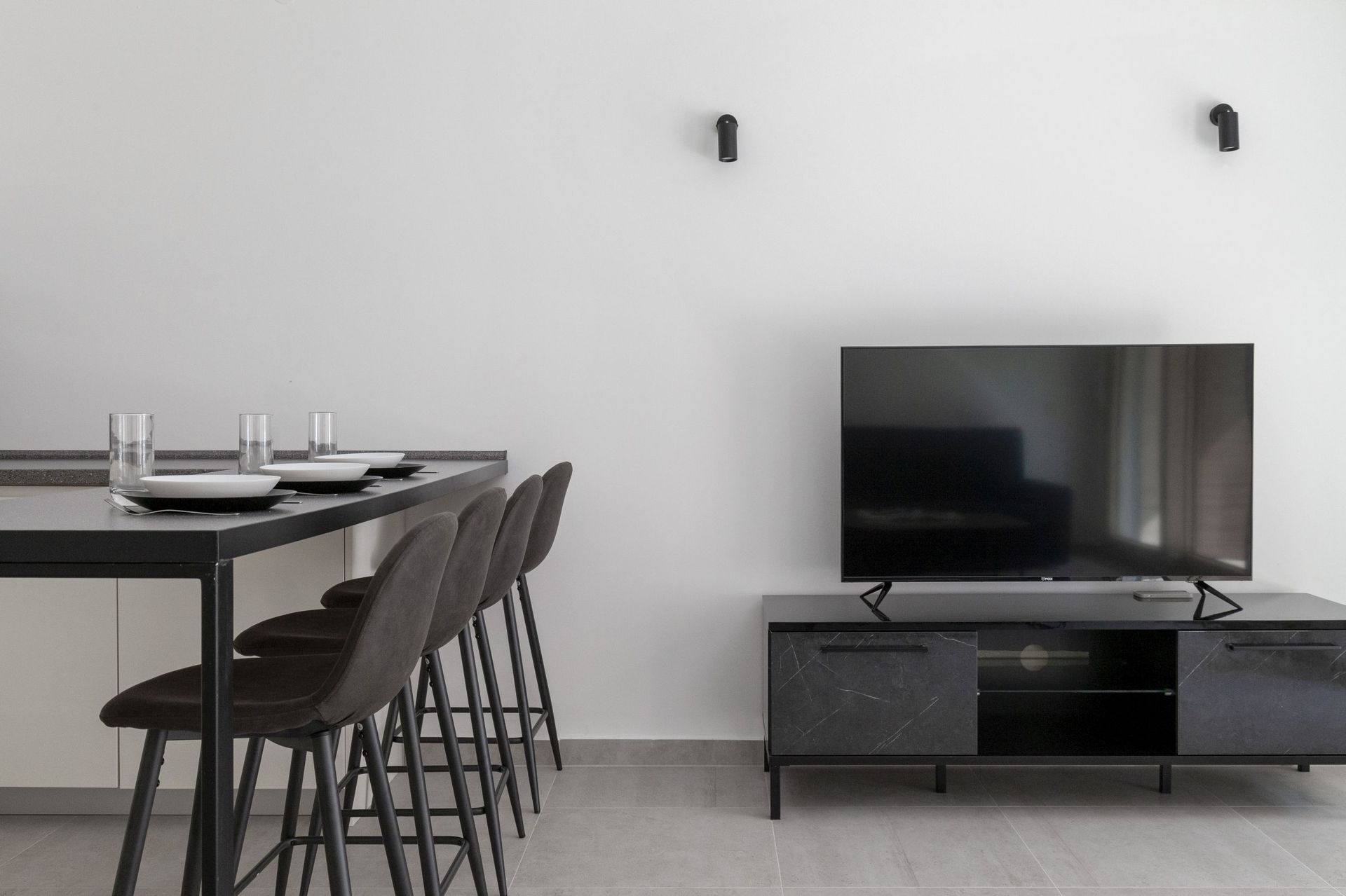 Modern living room with a bar counter and TV area in an apartment in Kotor, Montenegro: stylish loft-style interior.