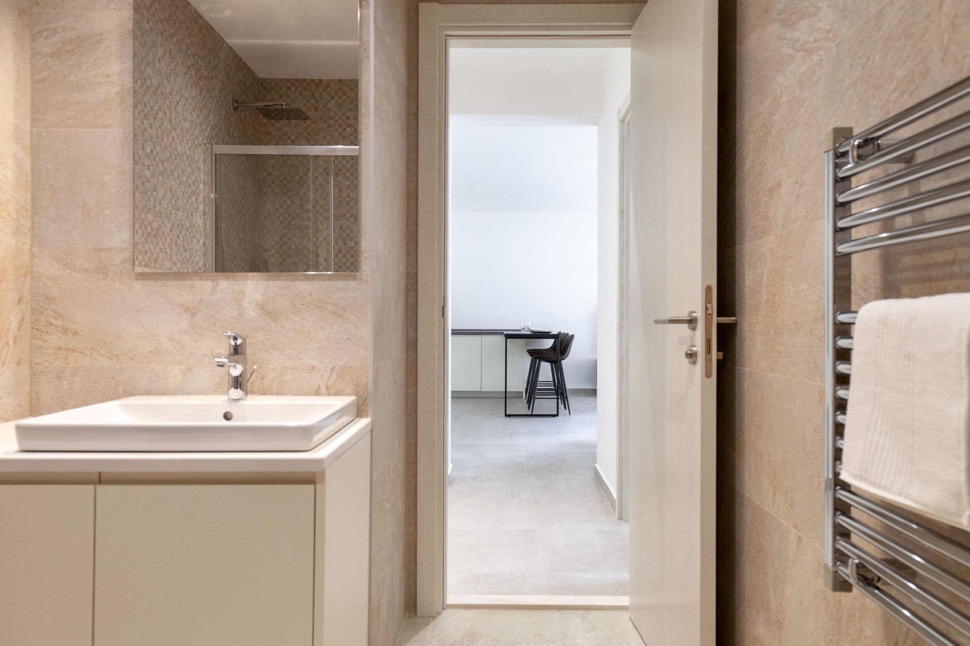 Modern bathroom with beige tiles in an apartment in Kotor, Montenegro, view of the kitchen with a breakfast bar.