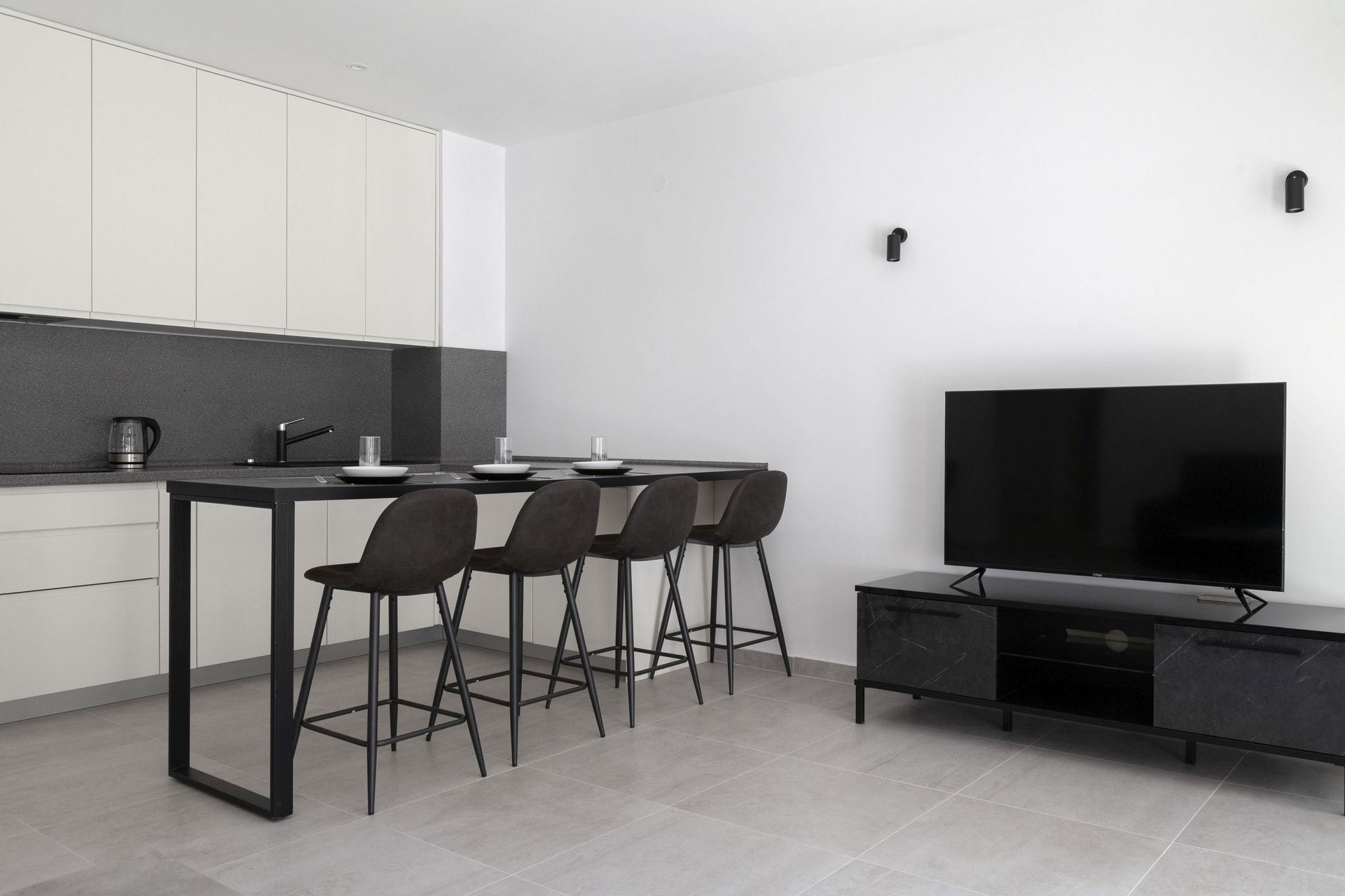 Modern kitchen-living room with a breakfast bar in an apartment in Kotor, Montenegro: a stylish black-and-white interior.