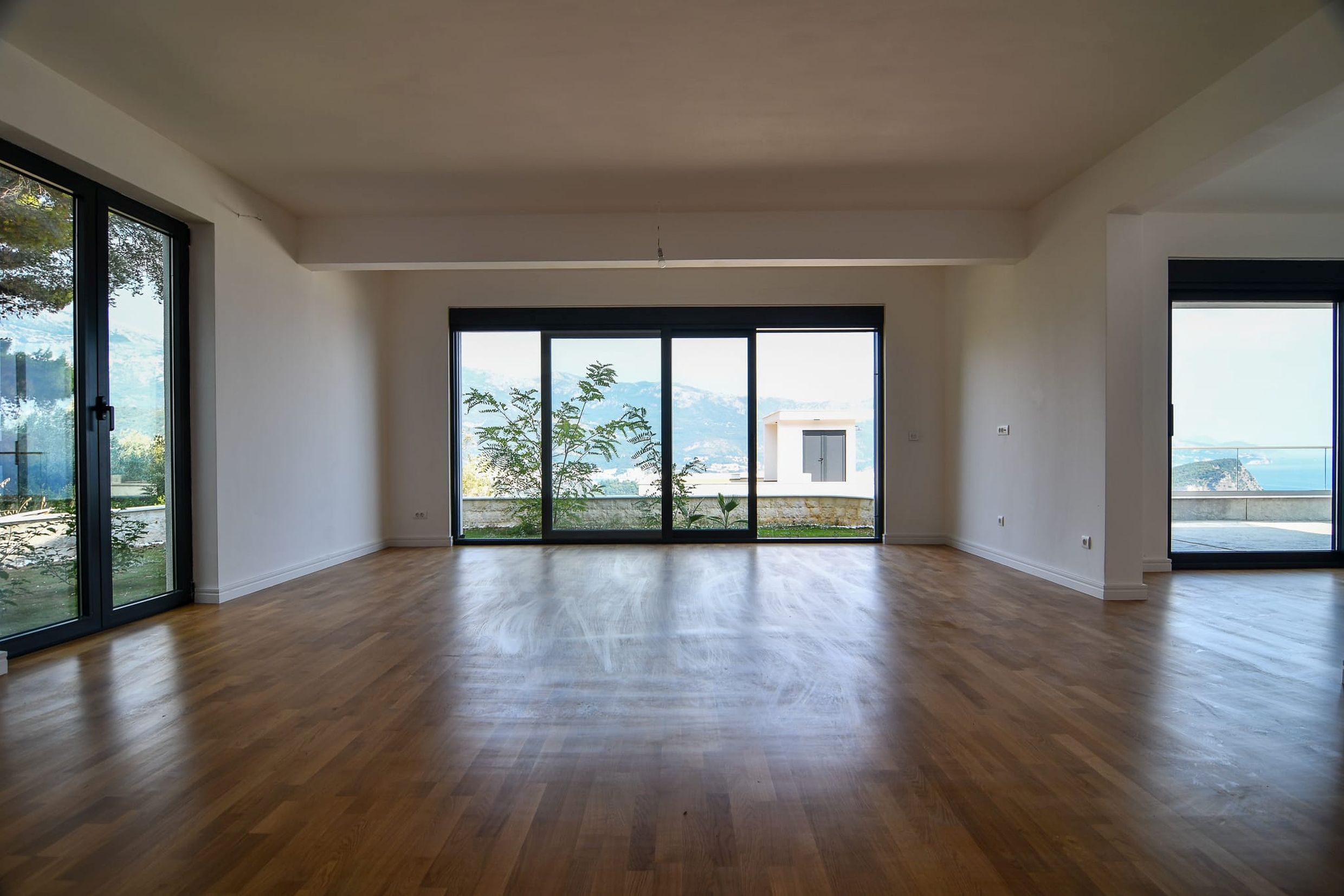 Spacious living room with panoramic windows and sea and mountain views in a villa, Budva, Montenegro.