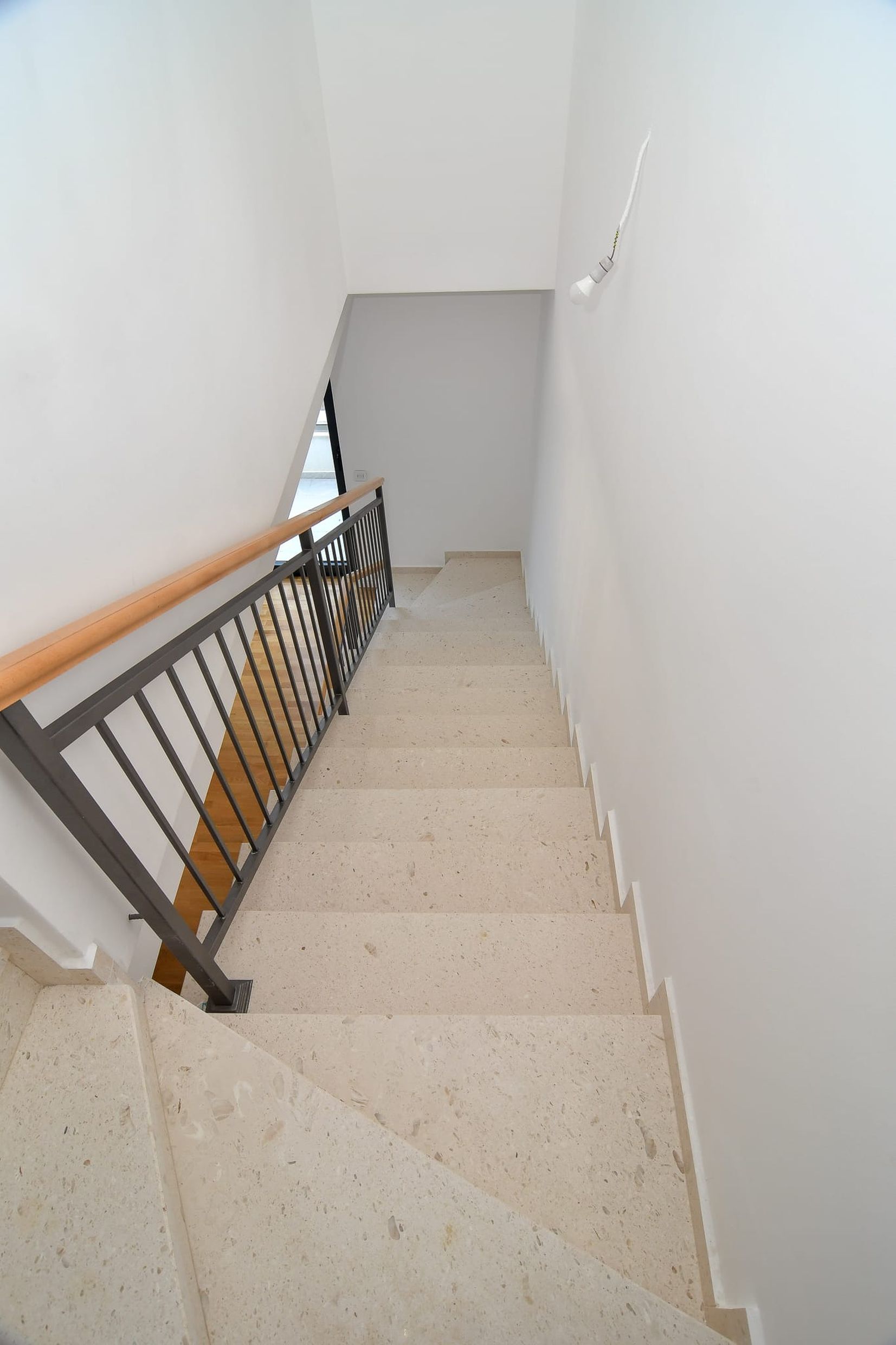 Staircase with stone steps and metal railings in a modern villa in Budva, Montenegro.