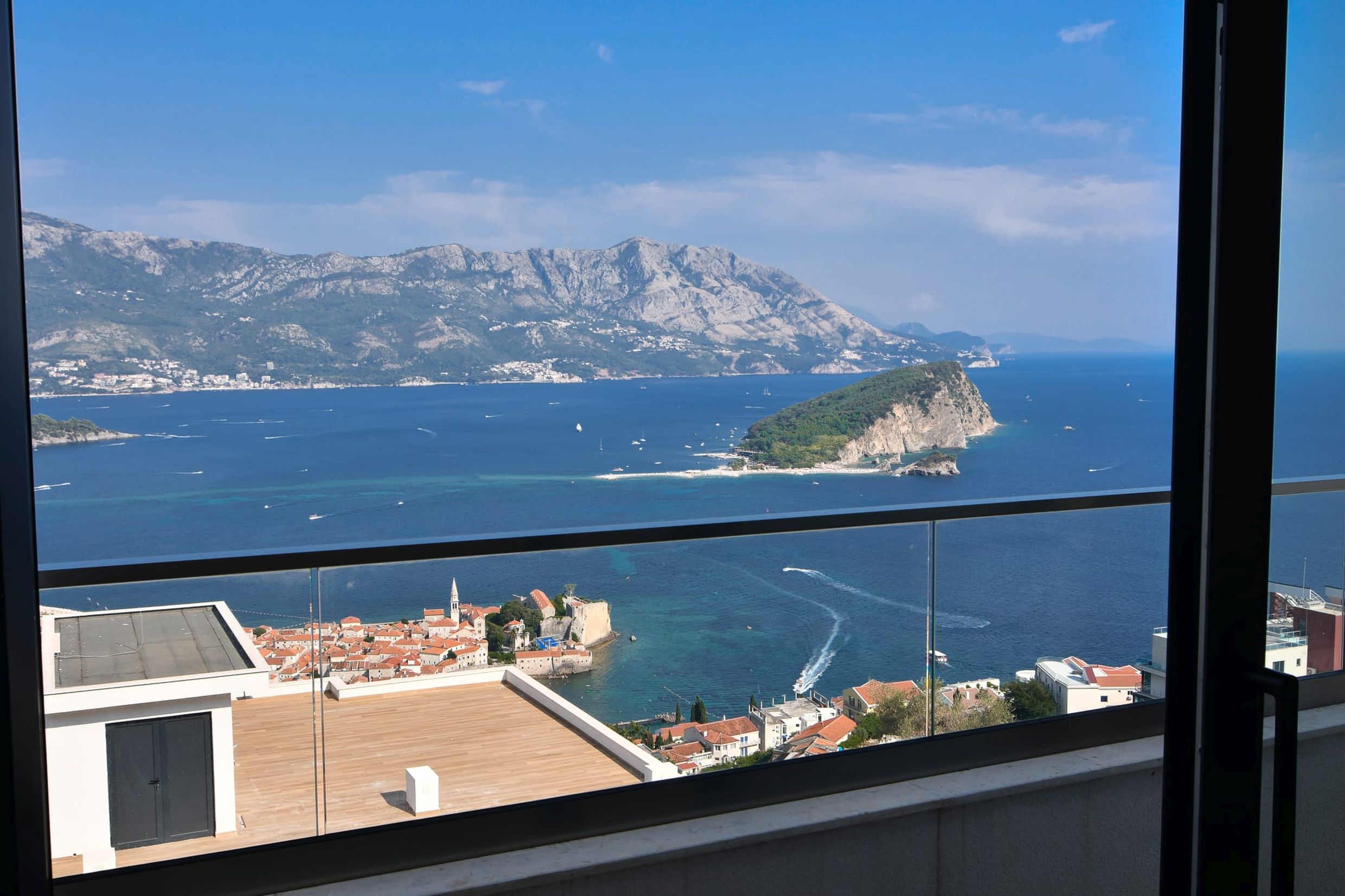 Panoramic view from the villa balcony in Budva, Montenegro: the sea, St. Nicholas Island, and the Old Town from above.