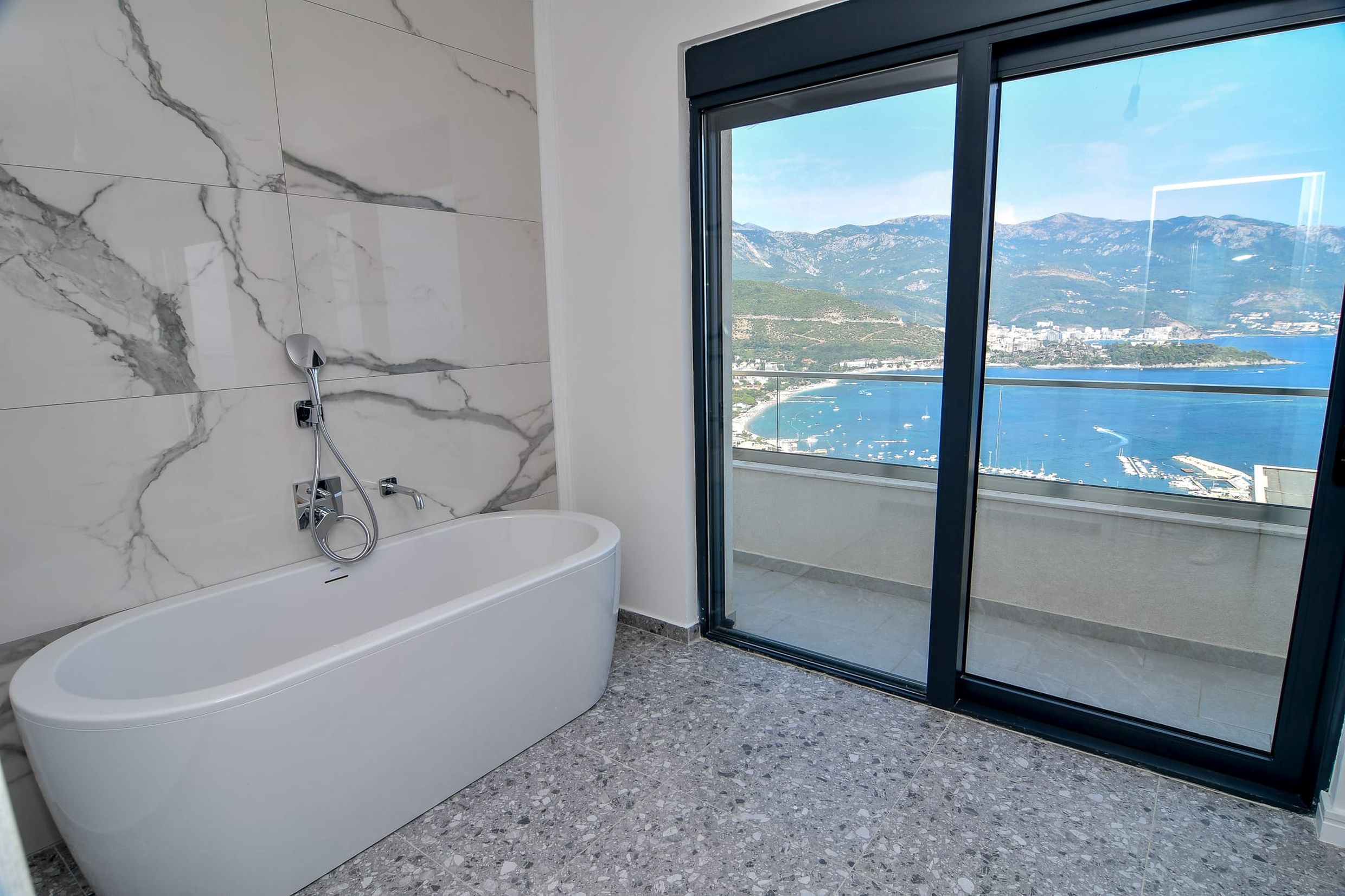 Bathroom with panoramic sea and mountain views in a villa in Budva, Montenegro: modern finishes and a stylish bathtub.