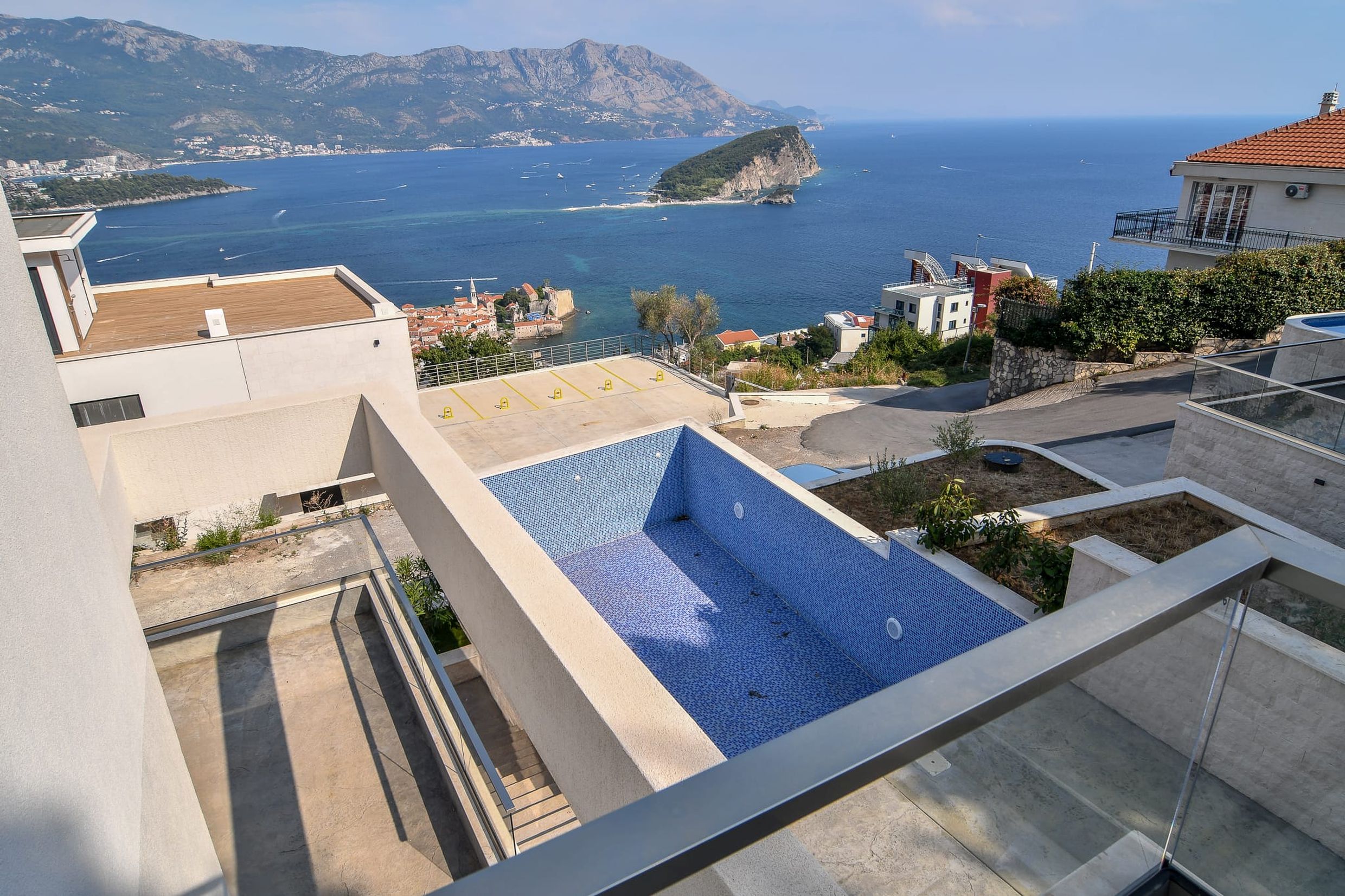 View of the pool and sea from the villa terrace in Budva, Montenegro: panorama of St. Nicholas Island and the old town.