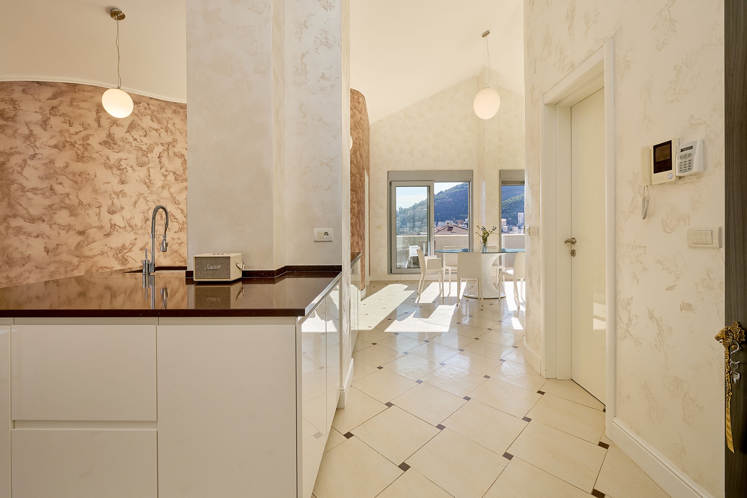 Modern kitchen in an apartment in Budva, Montenegro: bright interior, island layout, and mountain view from the window.