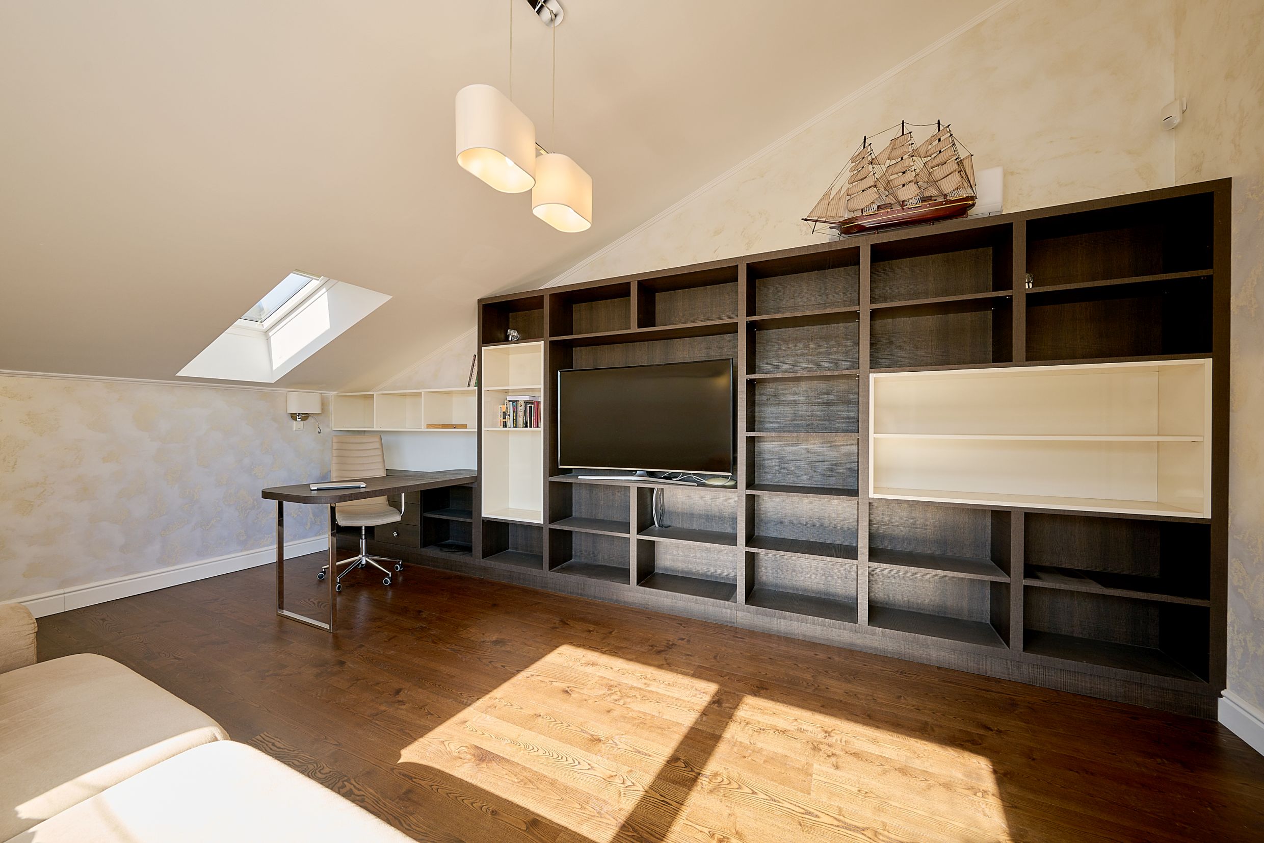 Living room with a workspace and shelving in an apartment in Budva, Montenegro: attic floor, TV area, and wooden flooring.