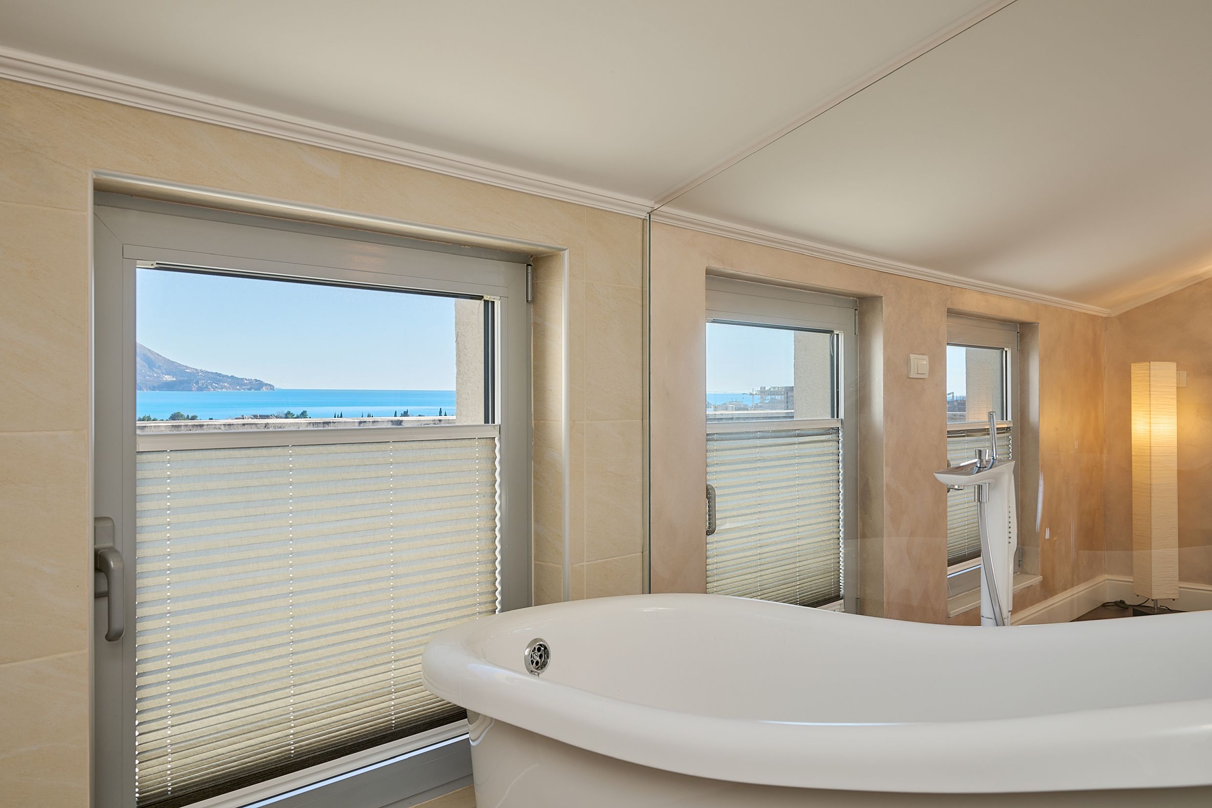Bathroom with a freestanding bathtub and panoramic sea view in an apartment in Budva, Montenegro.