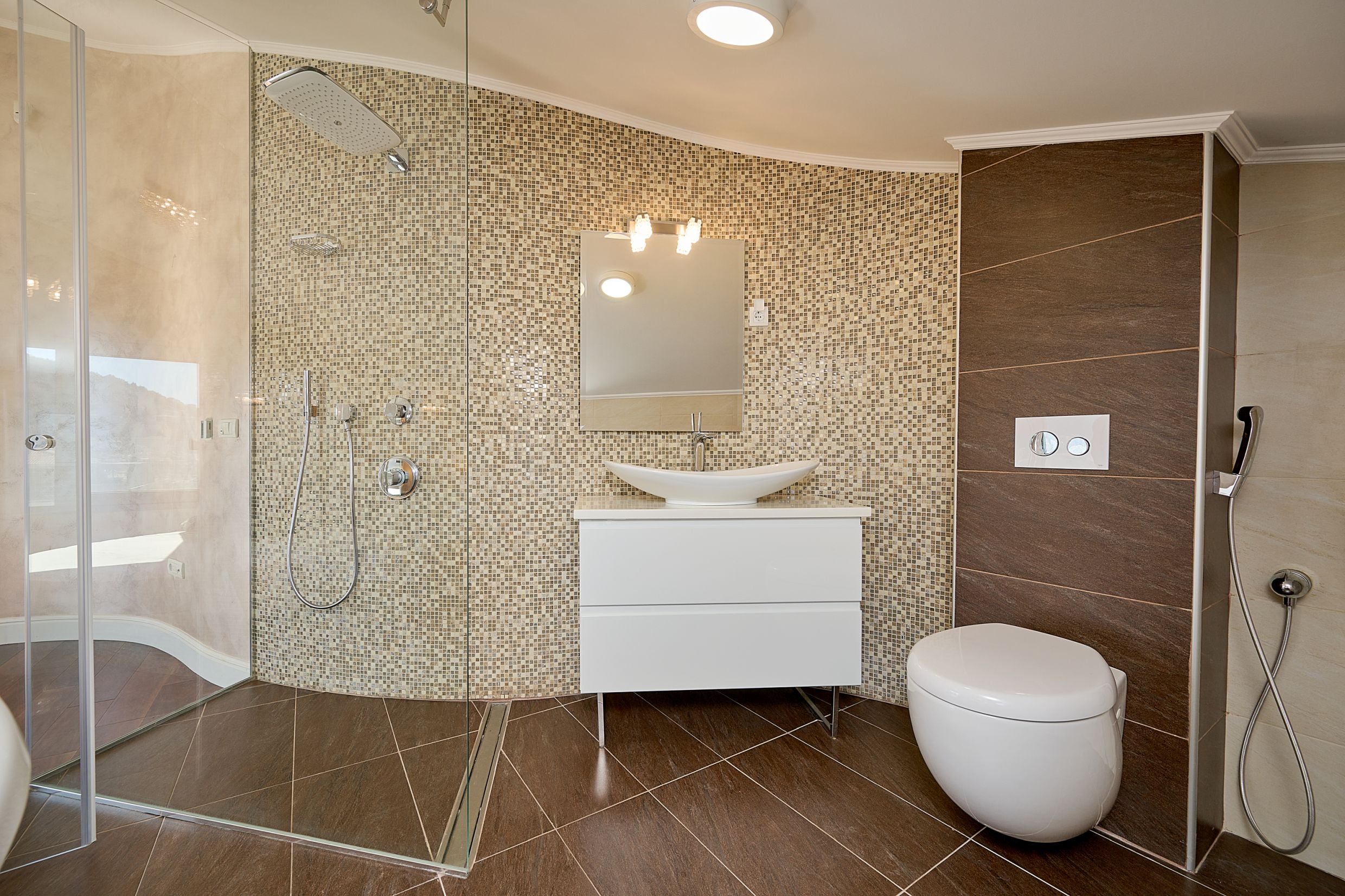 Modern bathroom with a shower cabin and mosaic finishes in an apartment in Budva, Montenegro.
