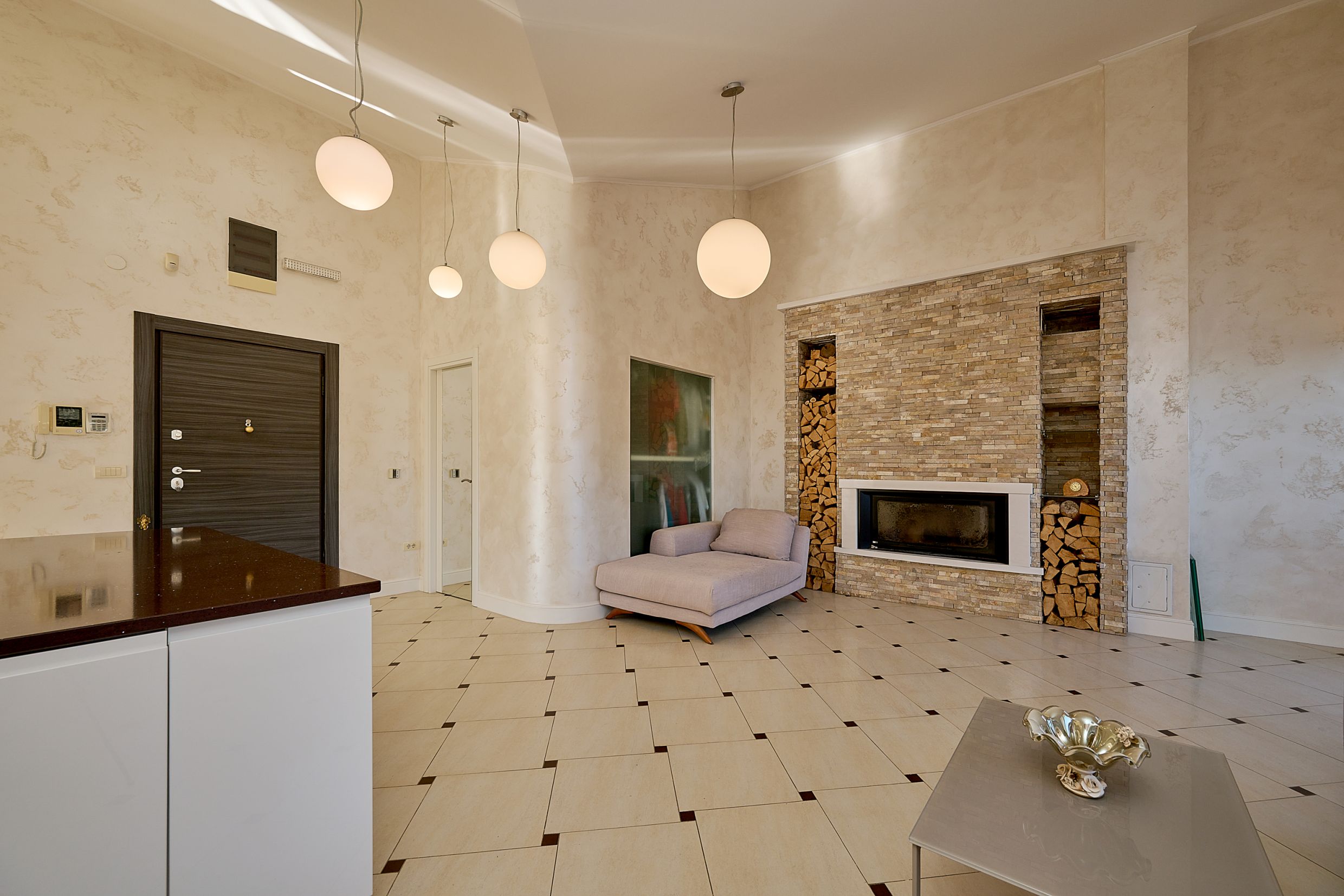 Living room with a fireplace, stone finishes, and light-colored furniture in a modern apartment in Budva, Montenegro.