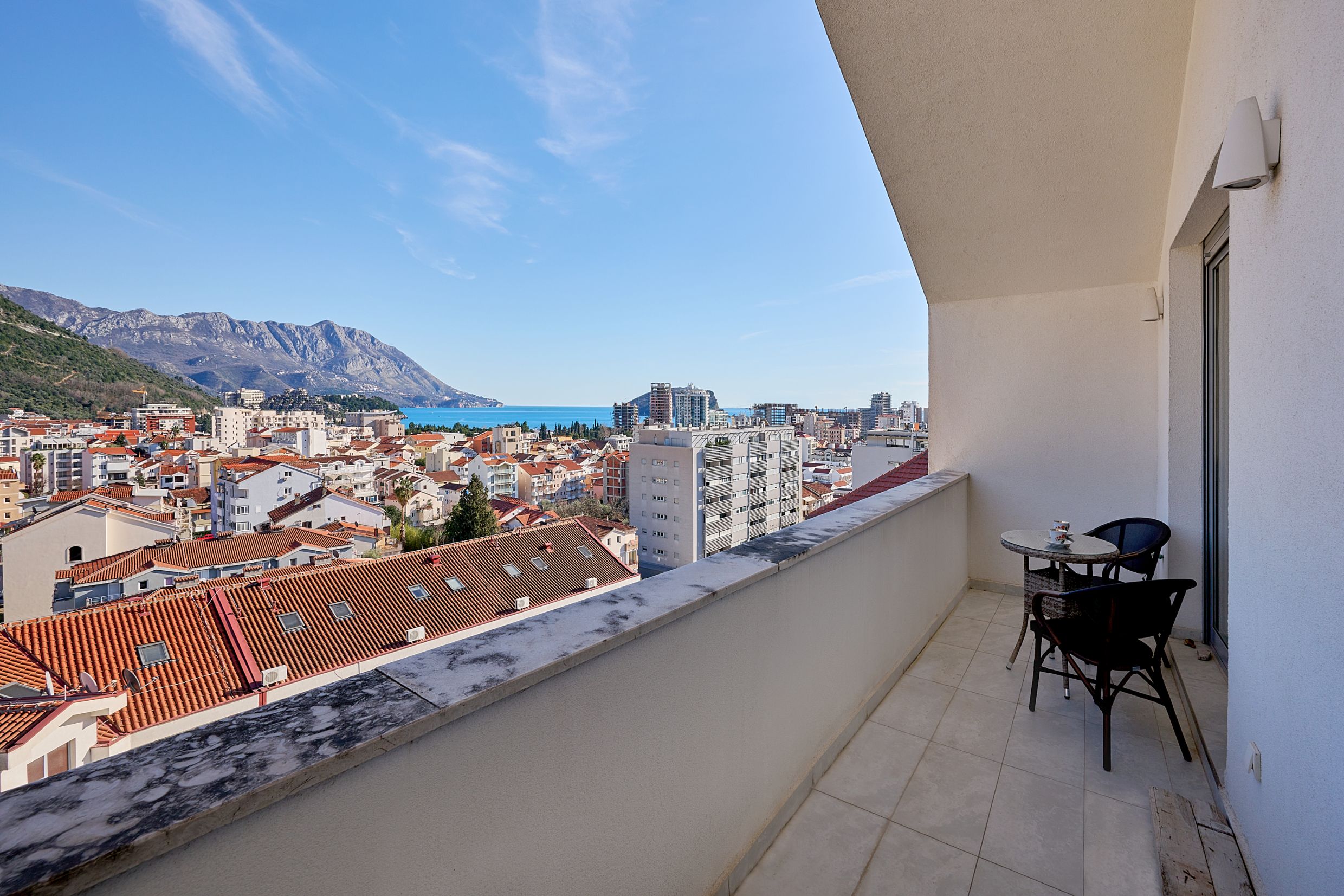 Balcony with furniture and panoramic views of the sea, mountains, and the city of Budva, Montenegro. Apartment No. 2566 with a terrace.