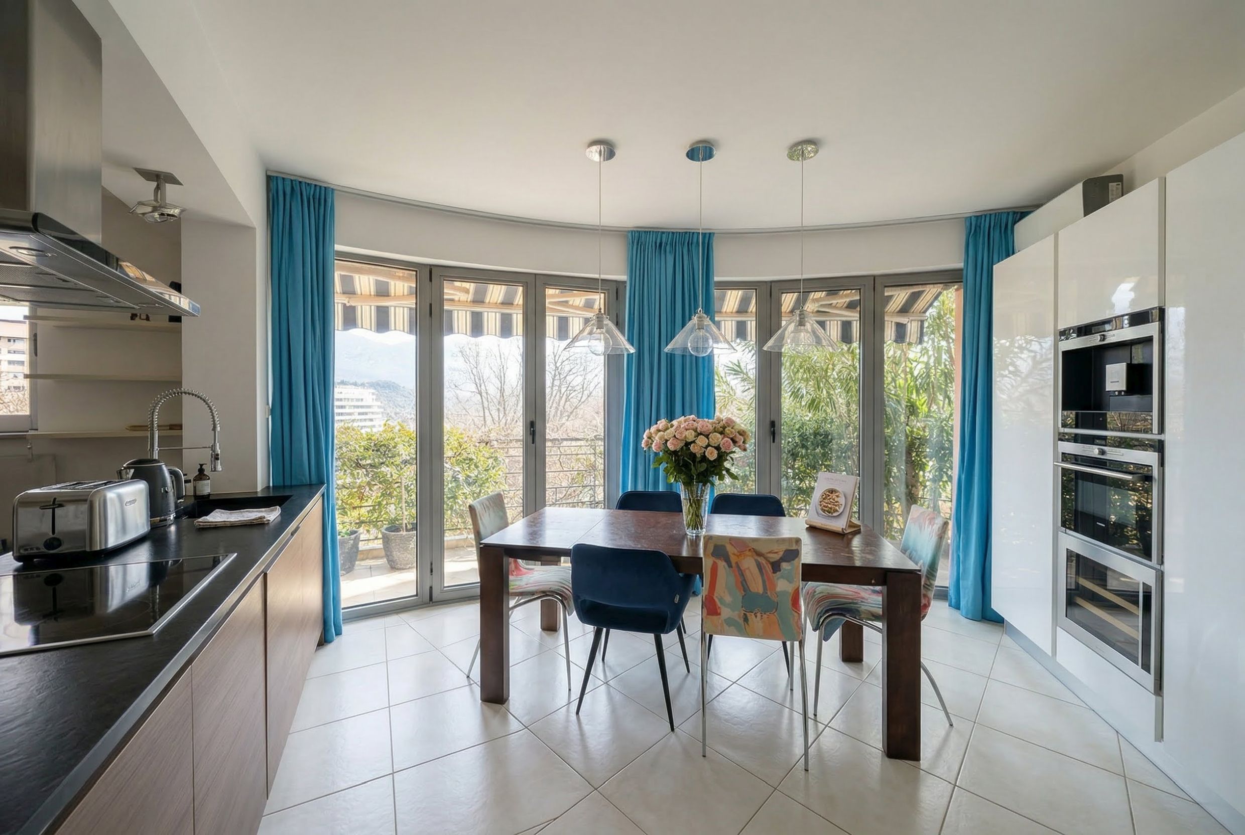 Modern kitchen-dining room in an apartment in Bečići, Montenegro: dining area with panoramic windows and access to the terrace.
