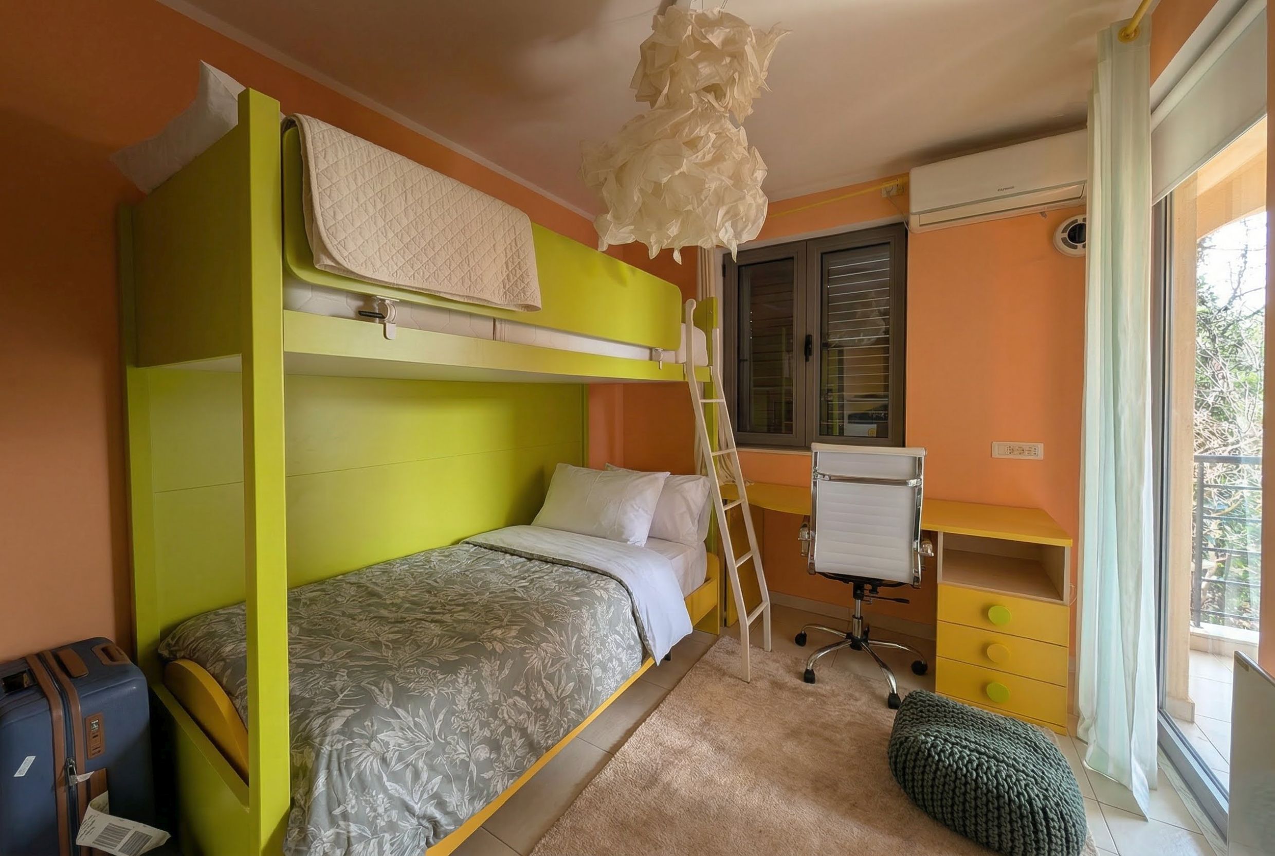 Children’s bedroom with a bunk bed, desk, and access to the balcony in an apartment, Becici, Montenegro.